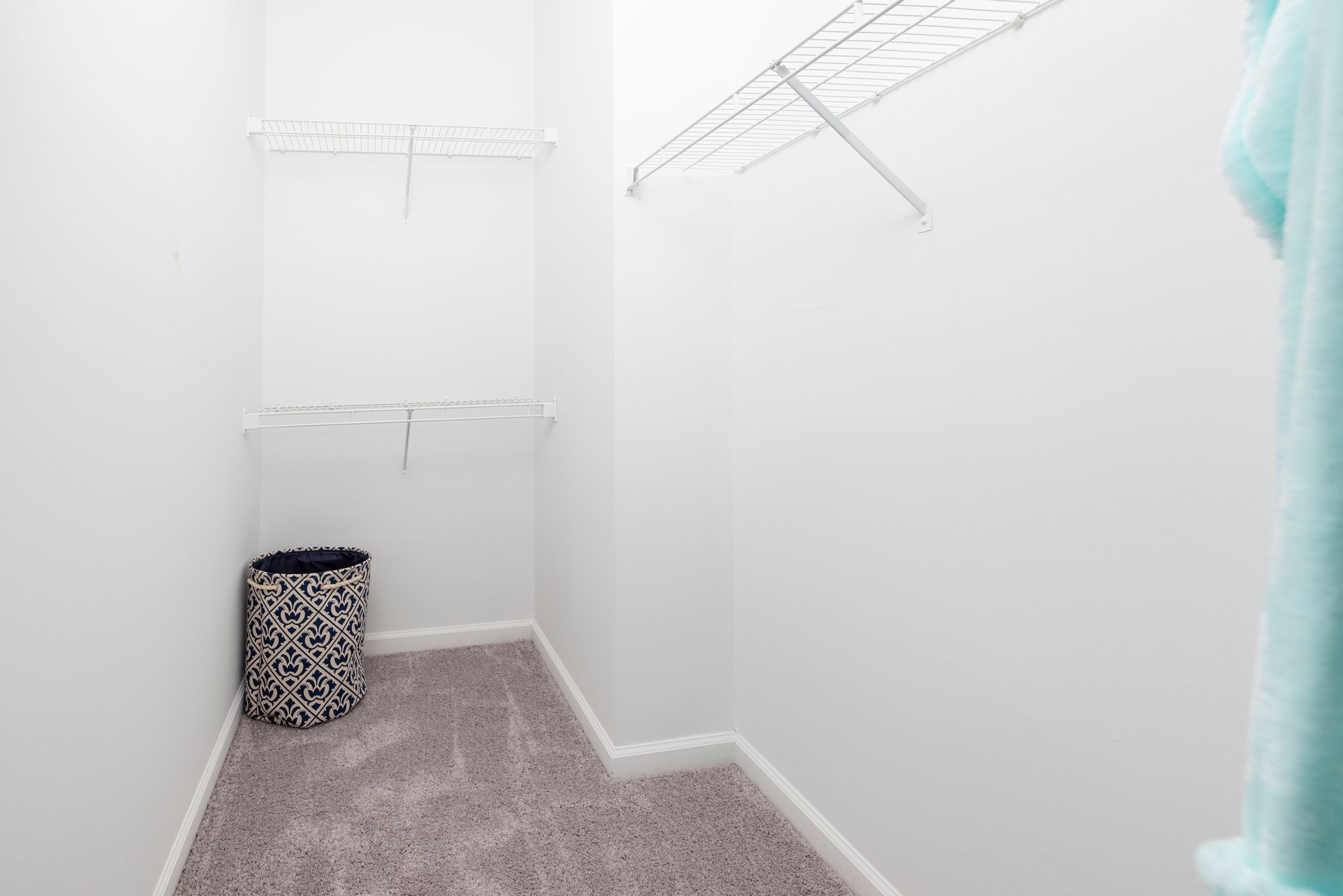 A walk in closet with a laundry basket in the corner | The Grove at Oakbrook