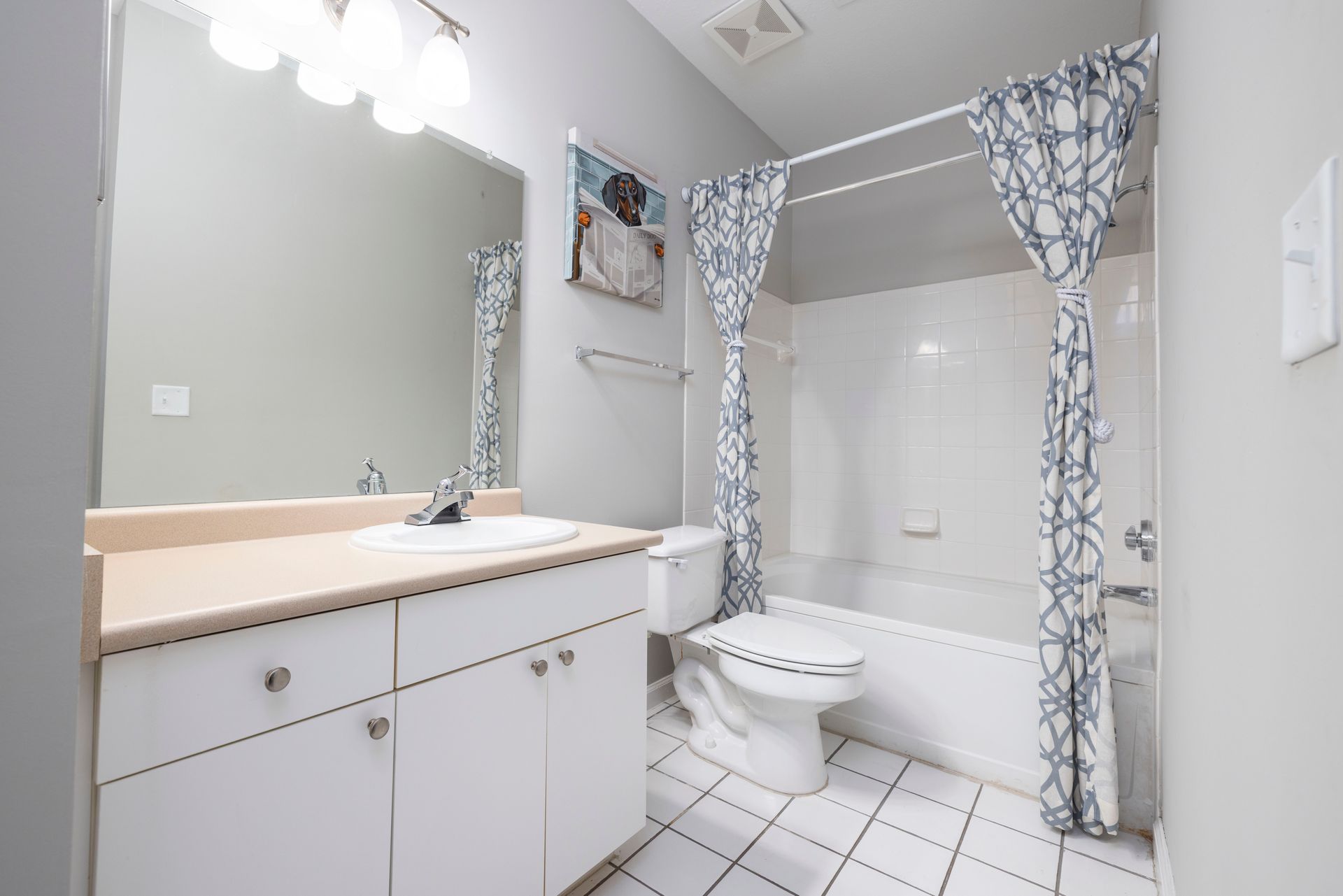 A bathroom with a toilet , sink , and shower | The Grove at Oakbrook