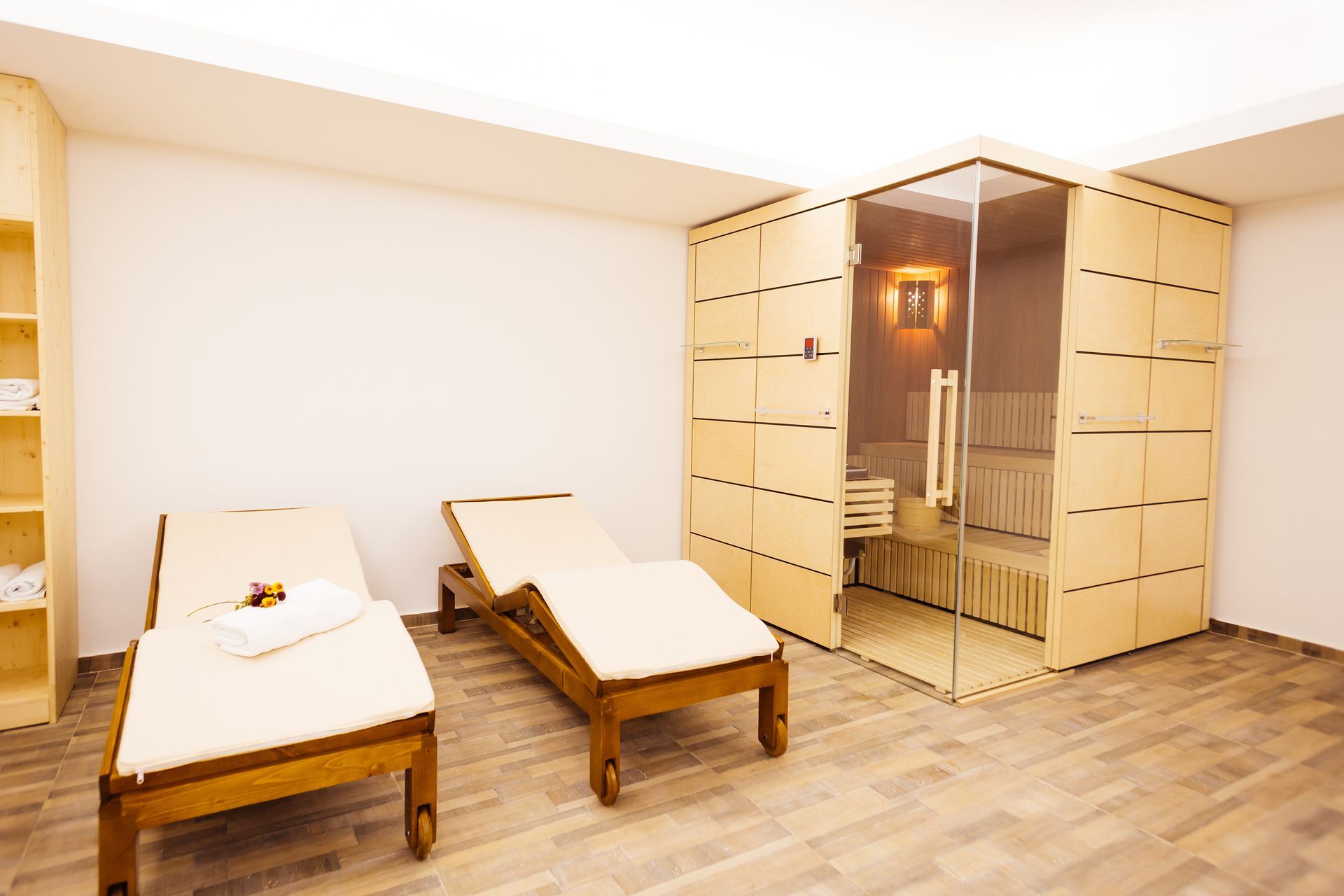 Two wooden lounge chairs and sauna in a spa.