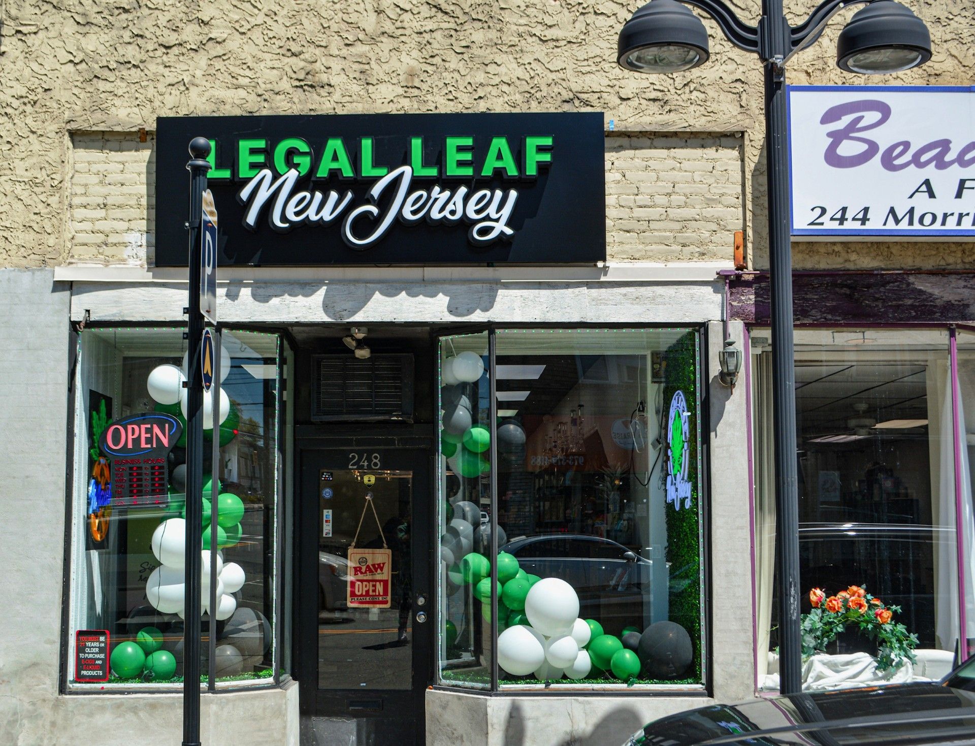 A store front with balloons and a sign that says legalleaf new jersey