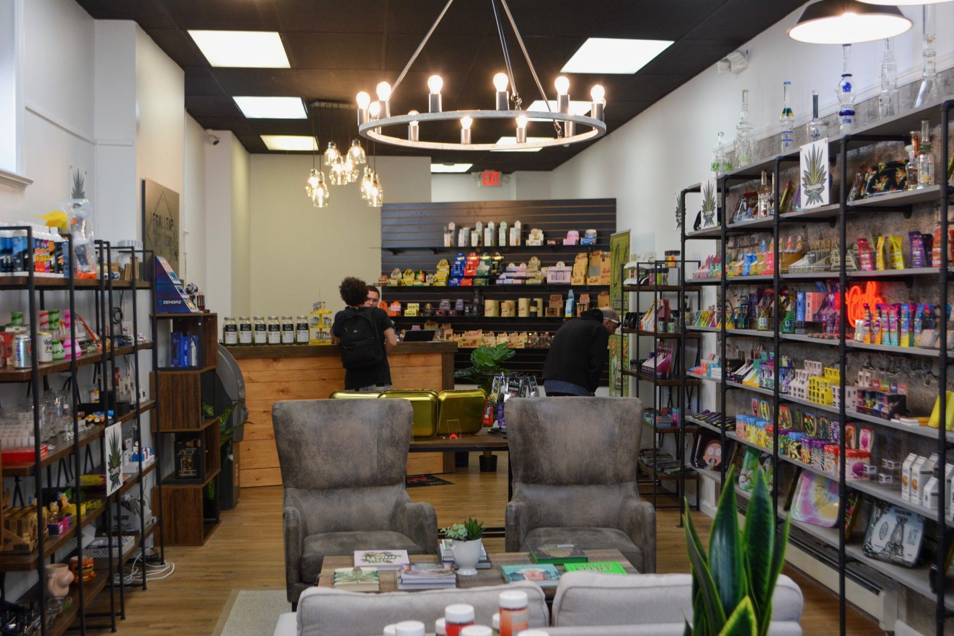 A store with a lot of shelves and chairs and a chandelier.