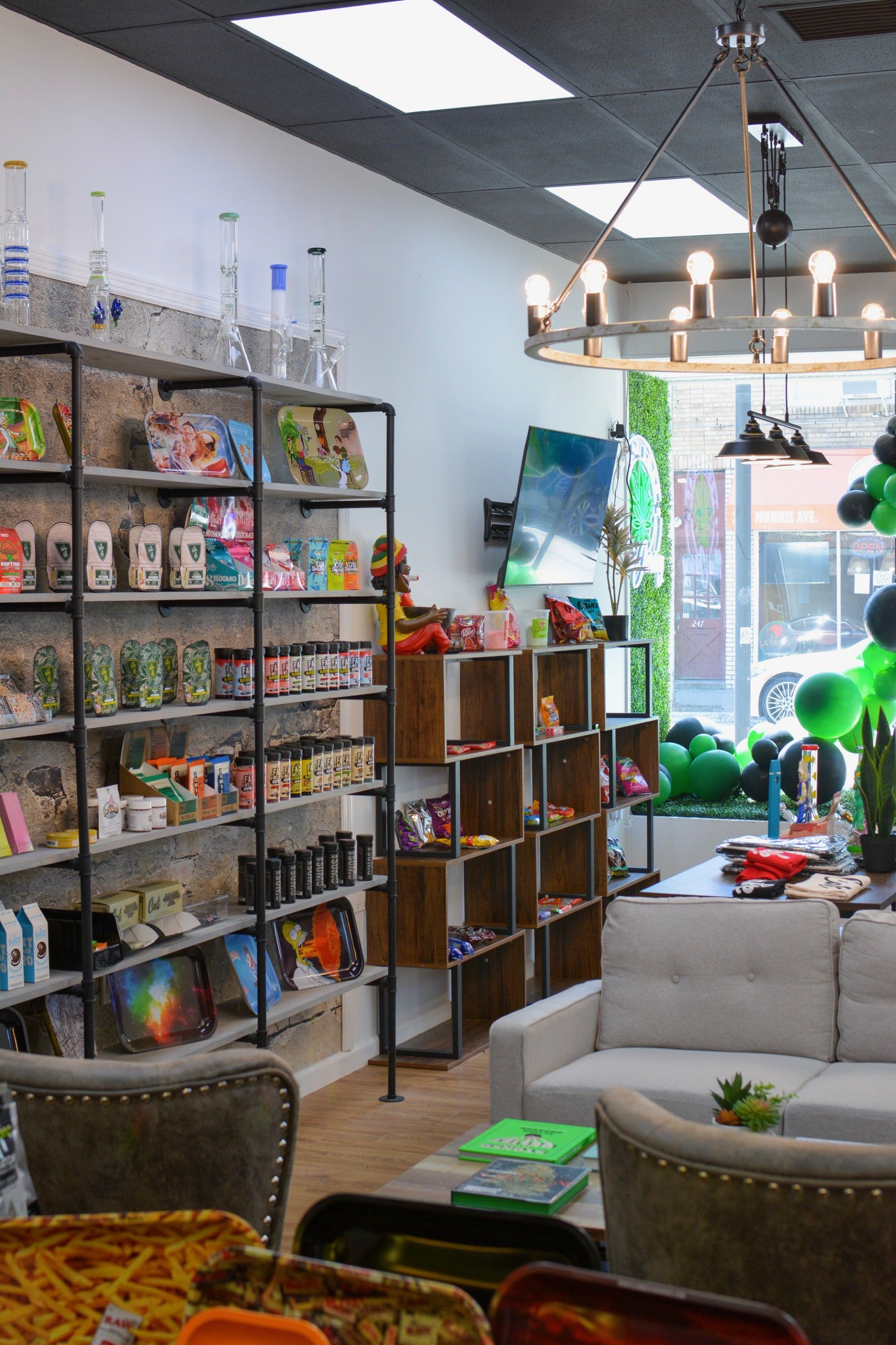 A room with a couch , chairs , shelves and a chandelier.