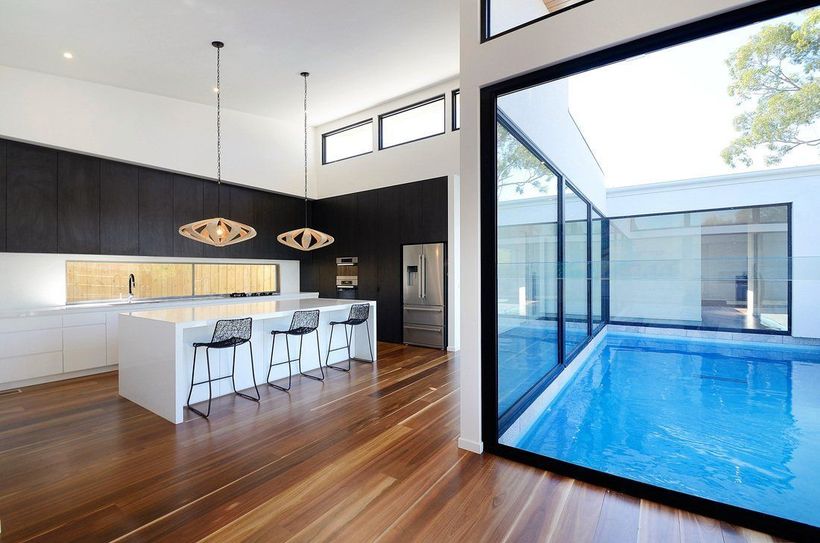 A kitchen with a swimming pool in the background