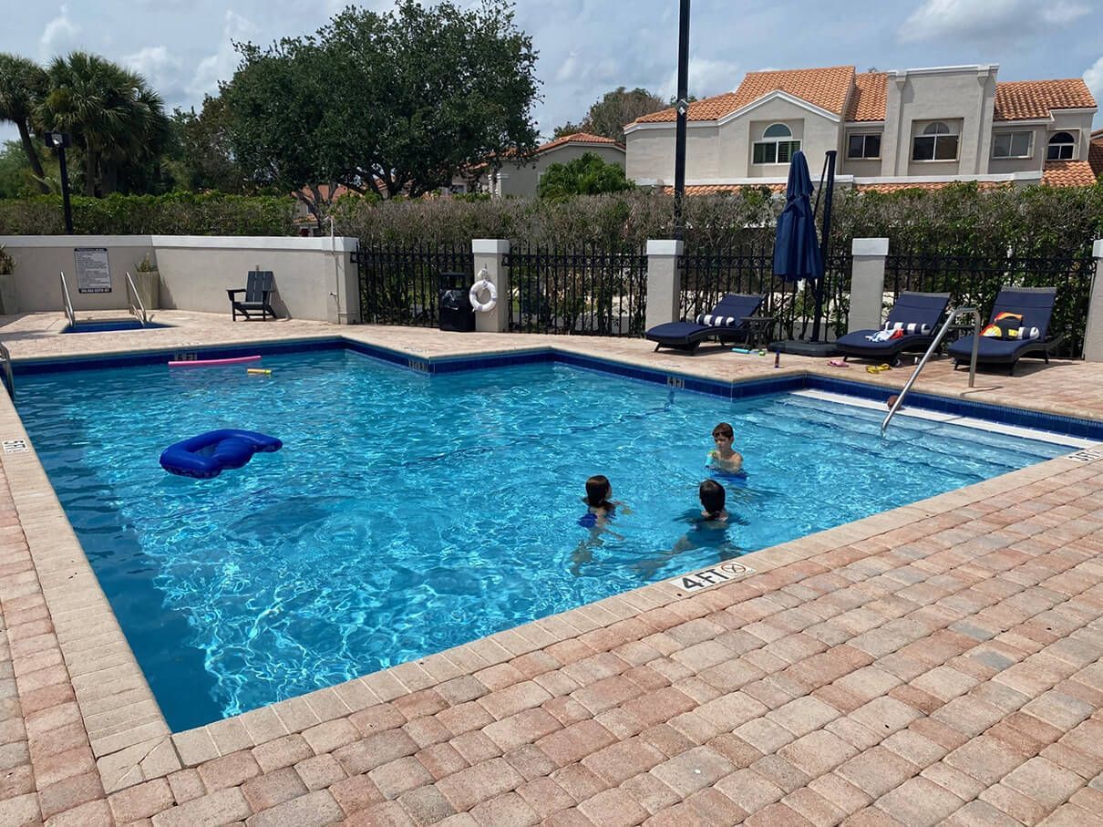 A group of people are swimming in a large swimming pool.