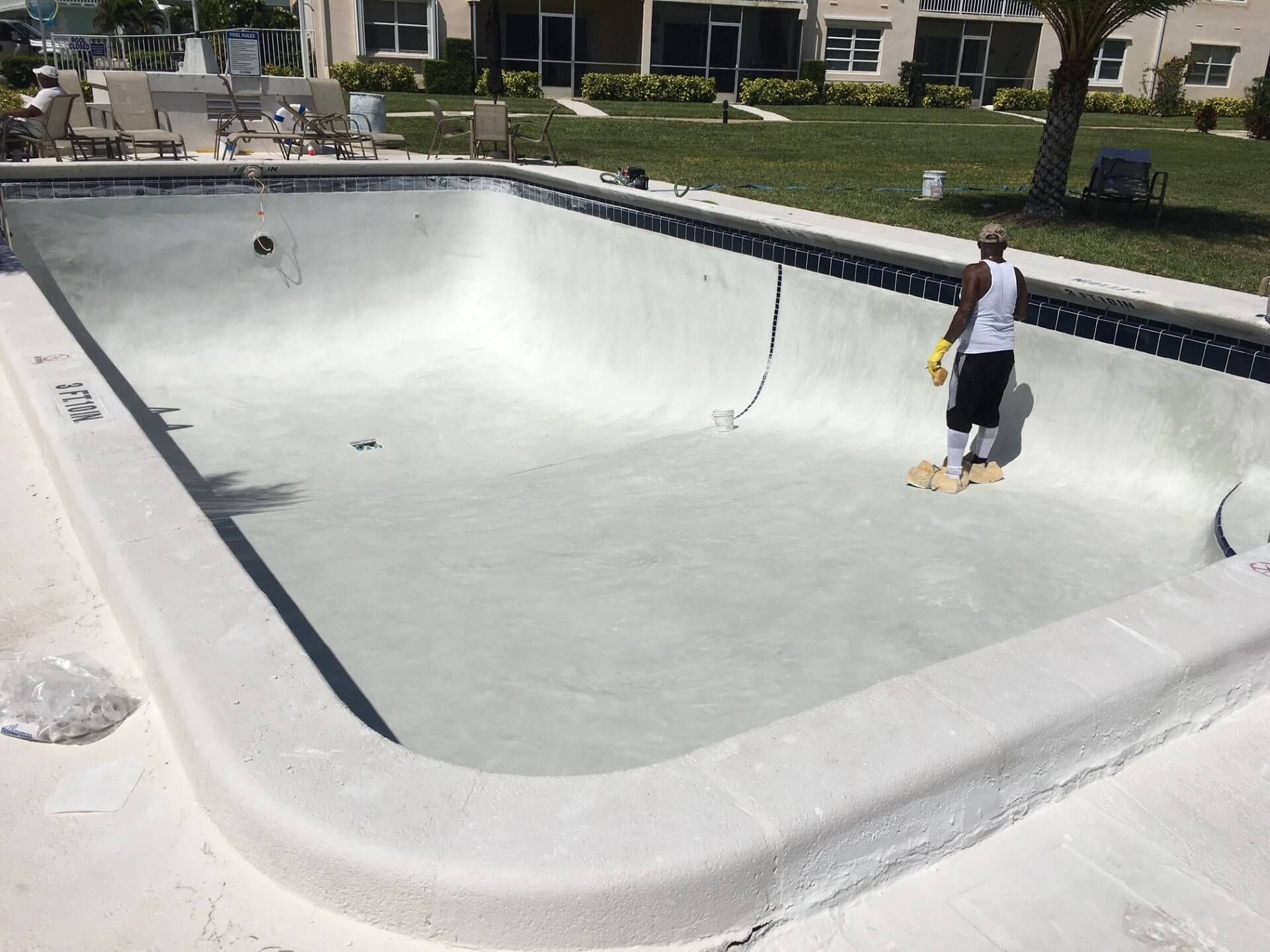 A man is standing in the middle of a swimming pool.