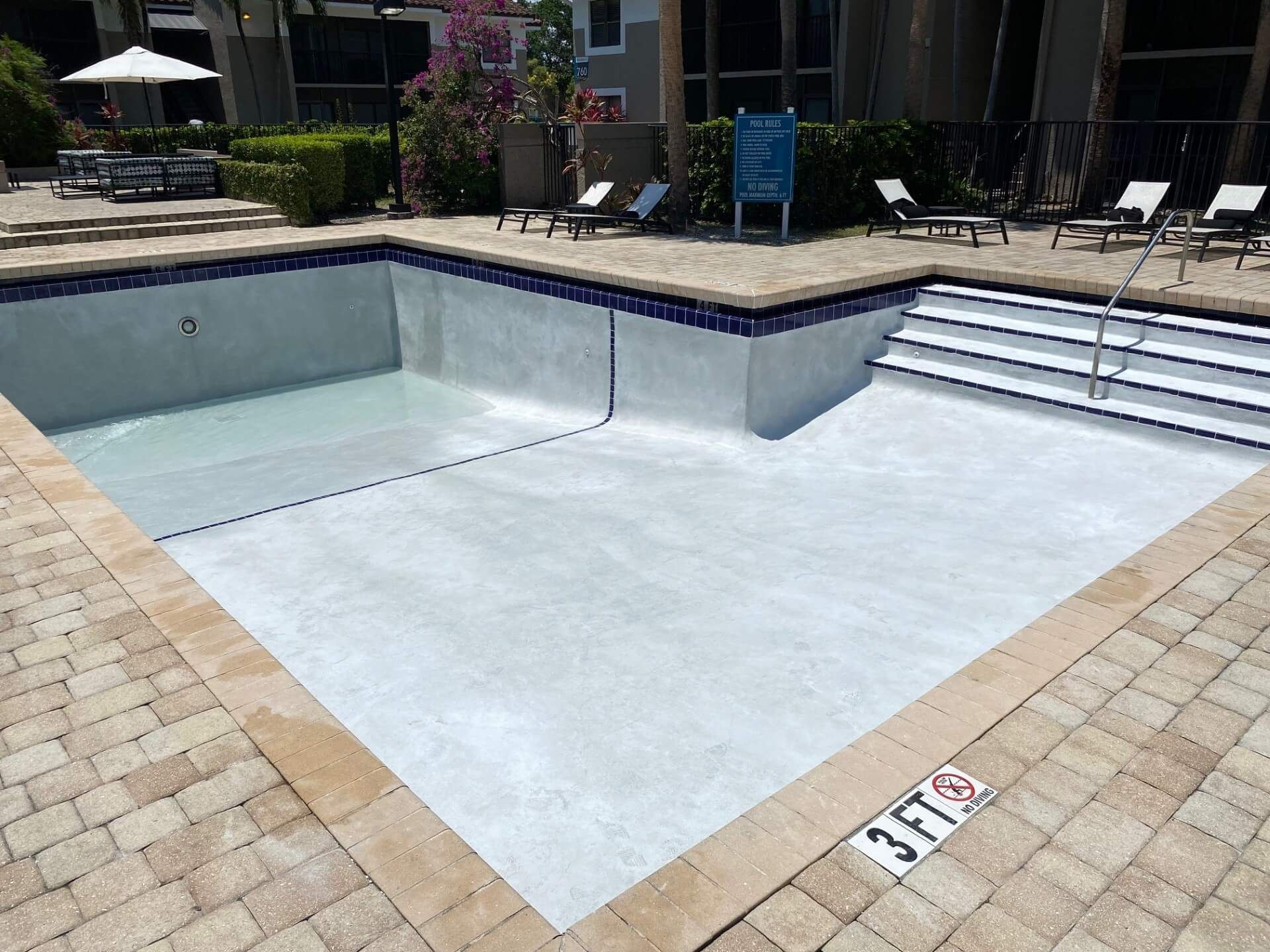 An empty swimming pool with a lifeguard on the side of it.