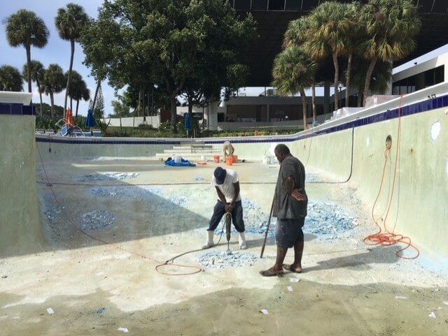 Two men are working on a swimming pool.
