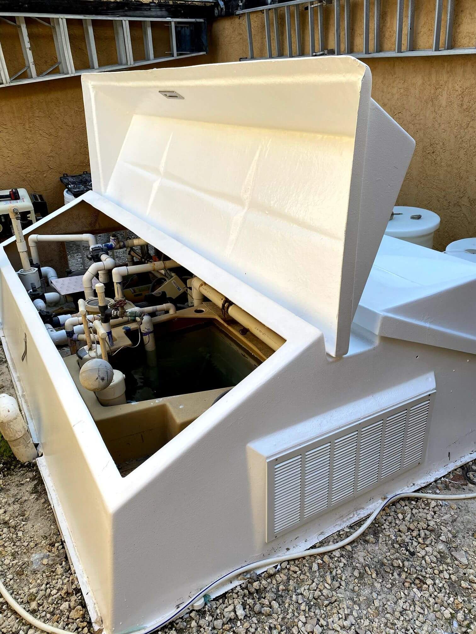 A white box with the lid open is sitting on the ground.