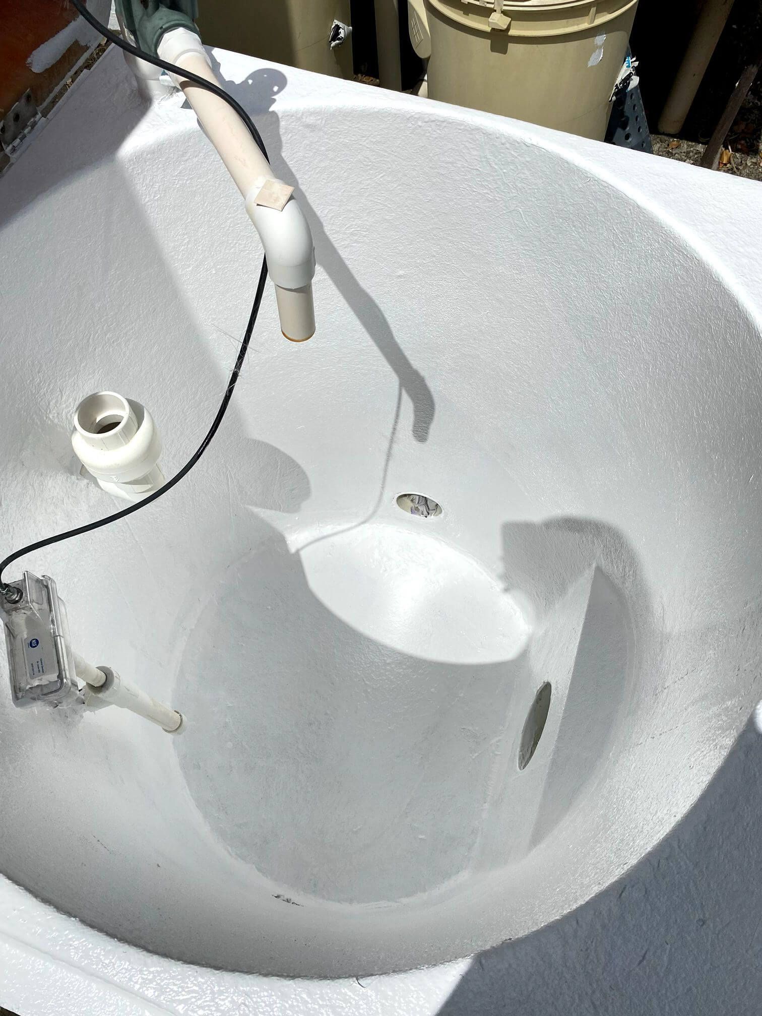 A white sink with a hose attached to it.