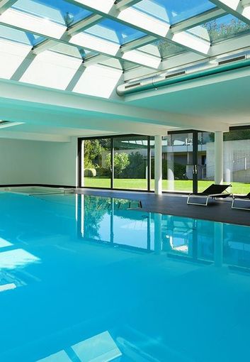 A large indoor swimming pool with a glass roof.