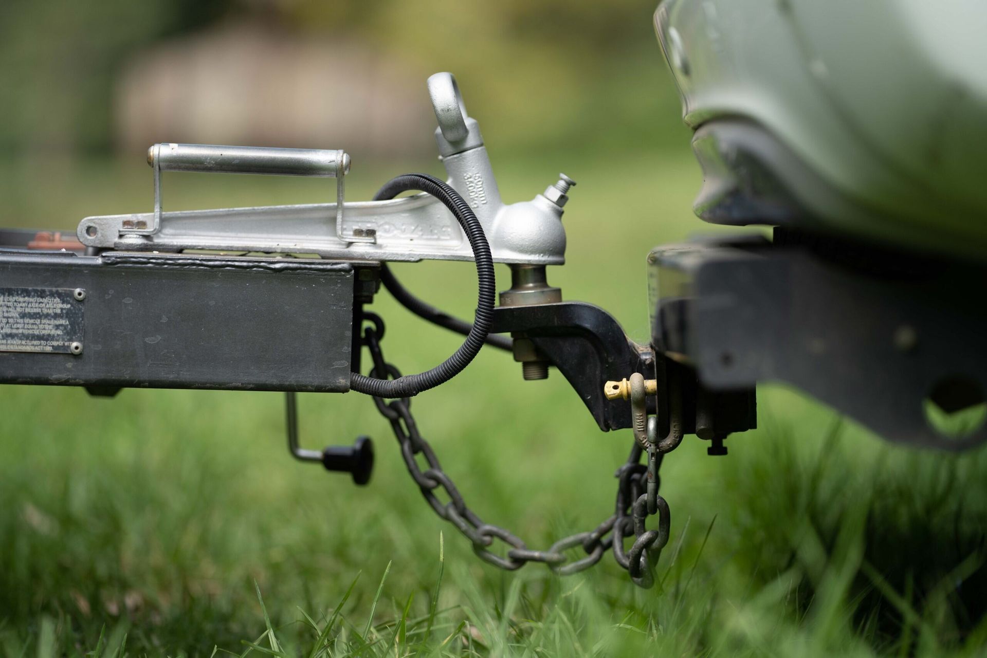 A Trailer is Being Towed by a Car in the Grass — Hervey Bay Tilt Tray Hire In Takura, QLD