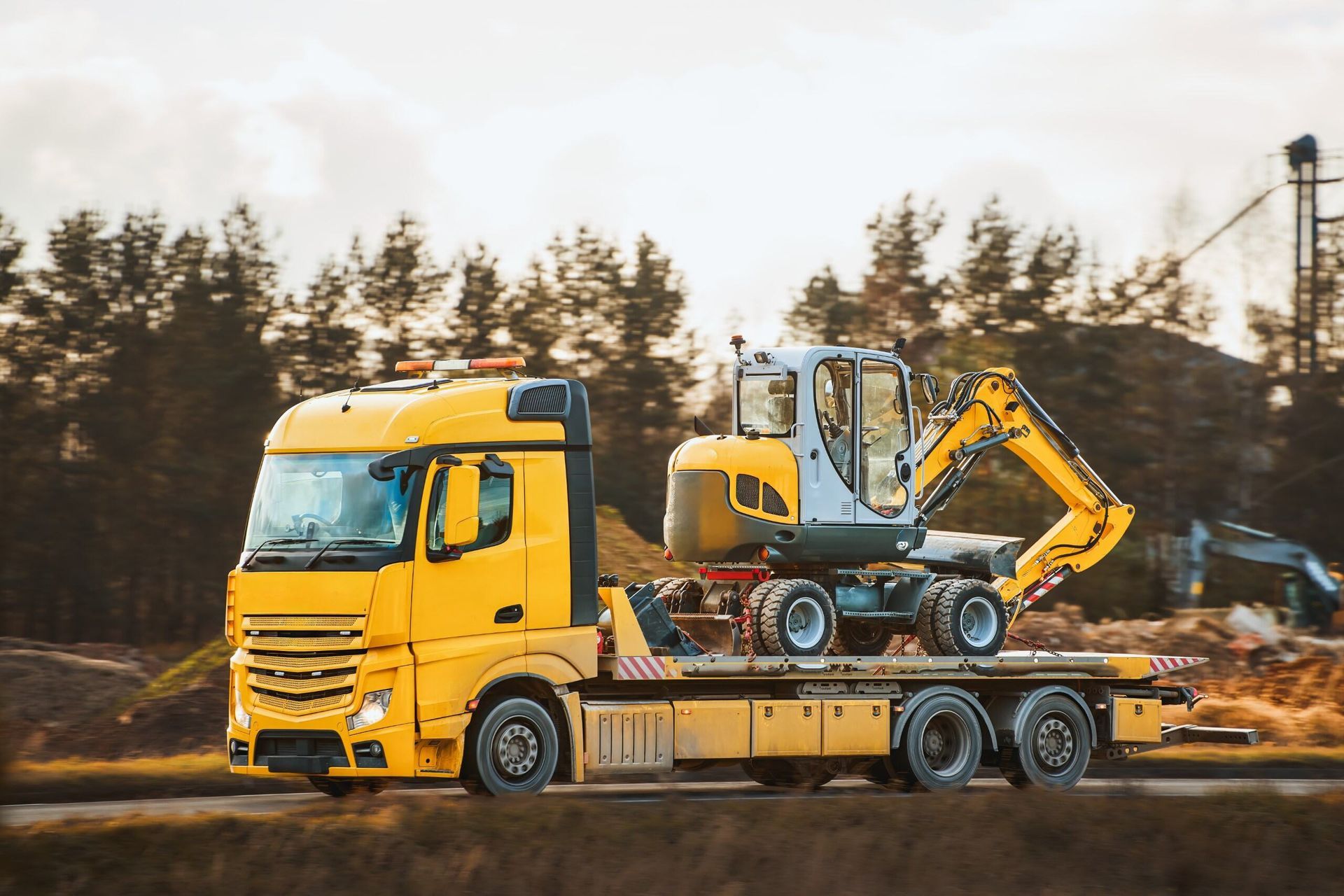 A Yellow Tow Truck is Carrying a Yellow Excavator on a Flatbed Trailer — Hervey Bay Tilt Tray Hire In Takura, QLD