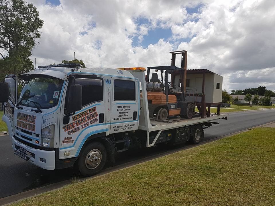 A Tow Truck With a Forklift on the Back is Parked on the Side of the Road — Hervey Bay Tilt Tray Hire In Takura, QLD