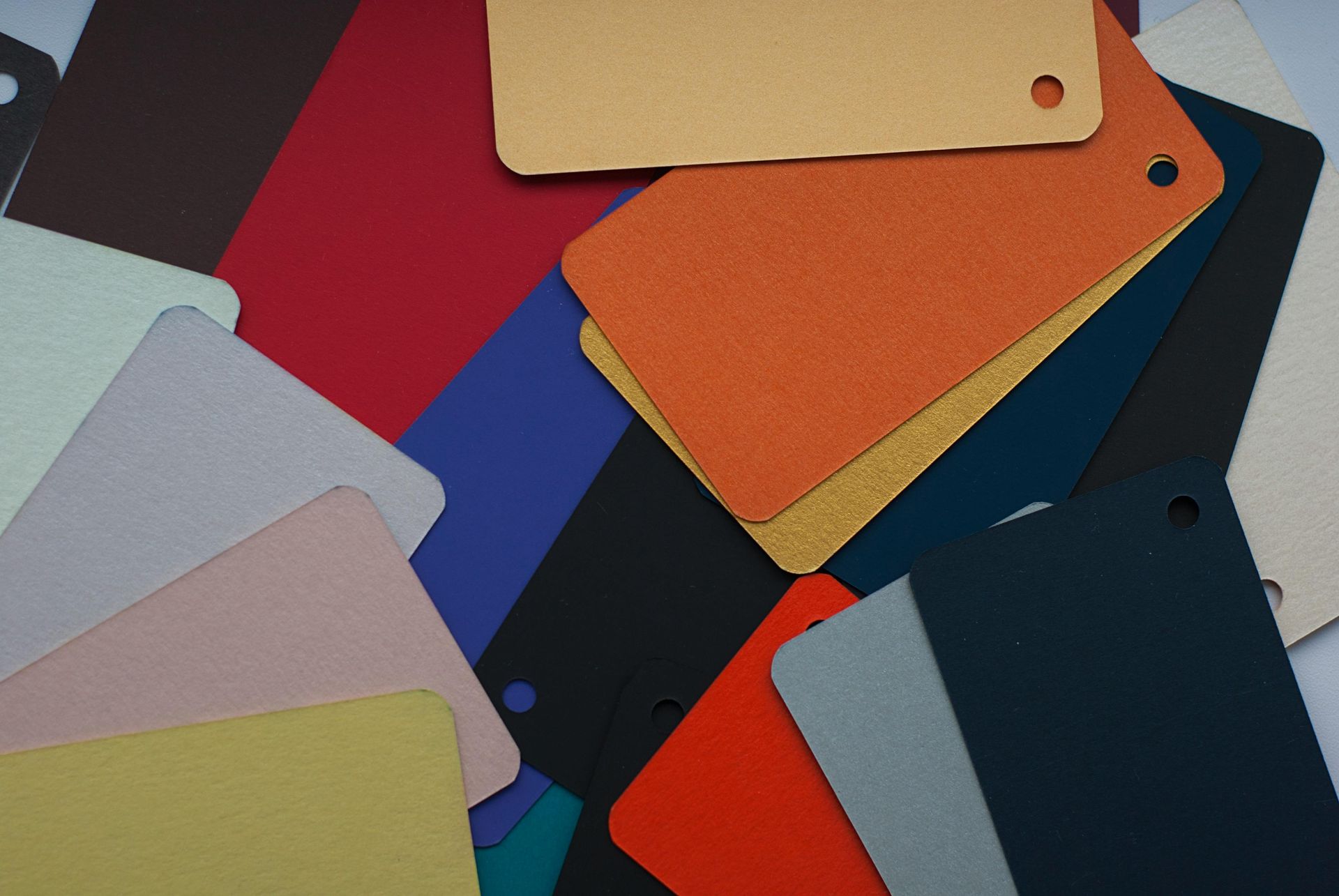 Scattered colorful paint swatches overlapping on a dark background