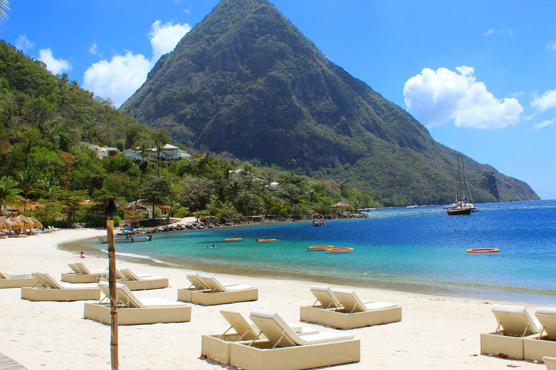 A beach with chairs and a mountain in the background