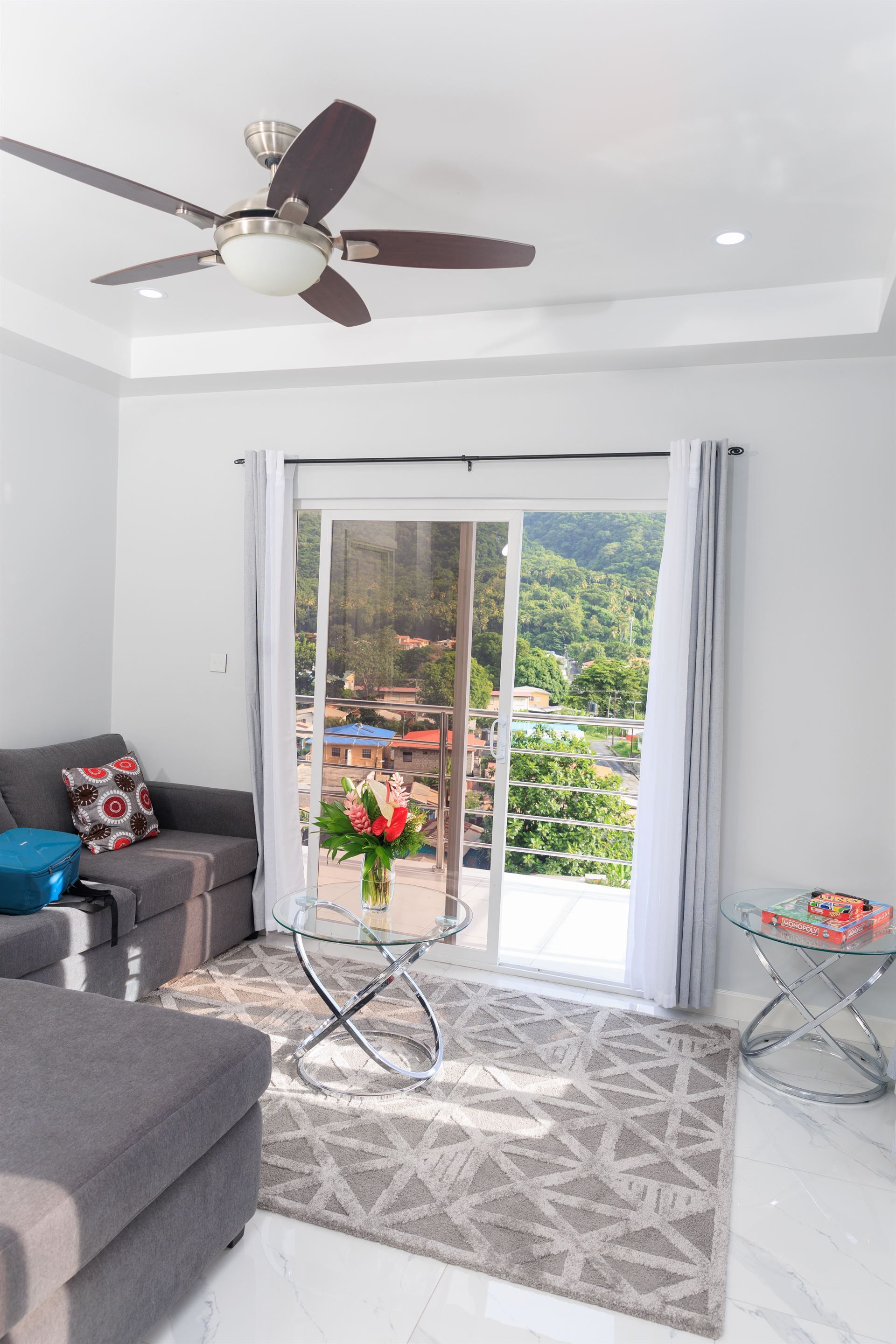 A living room with a sliding glass door and a ceiling fan.