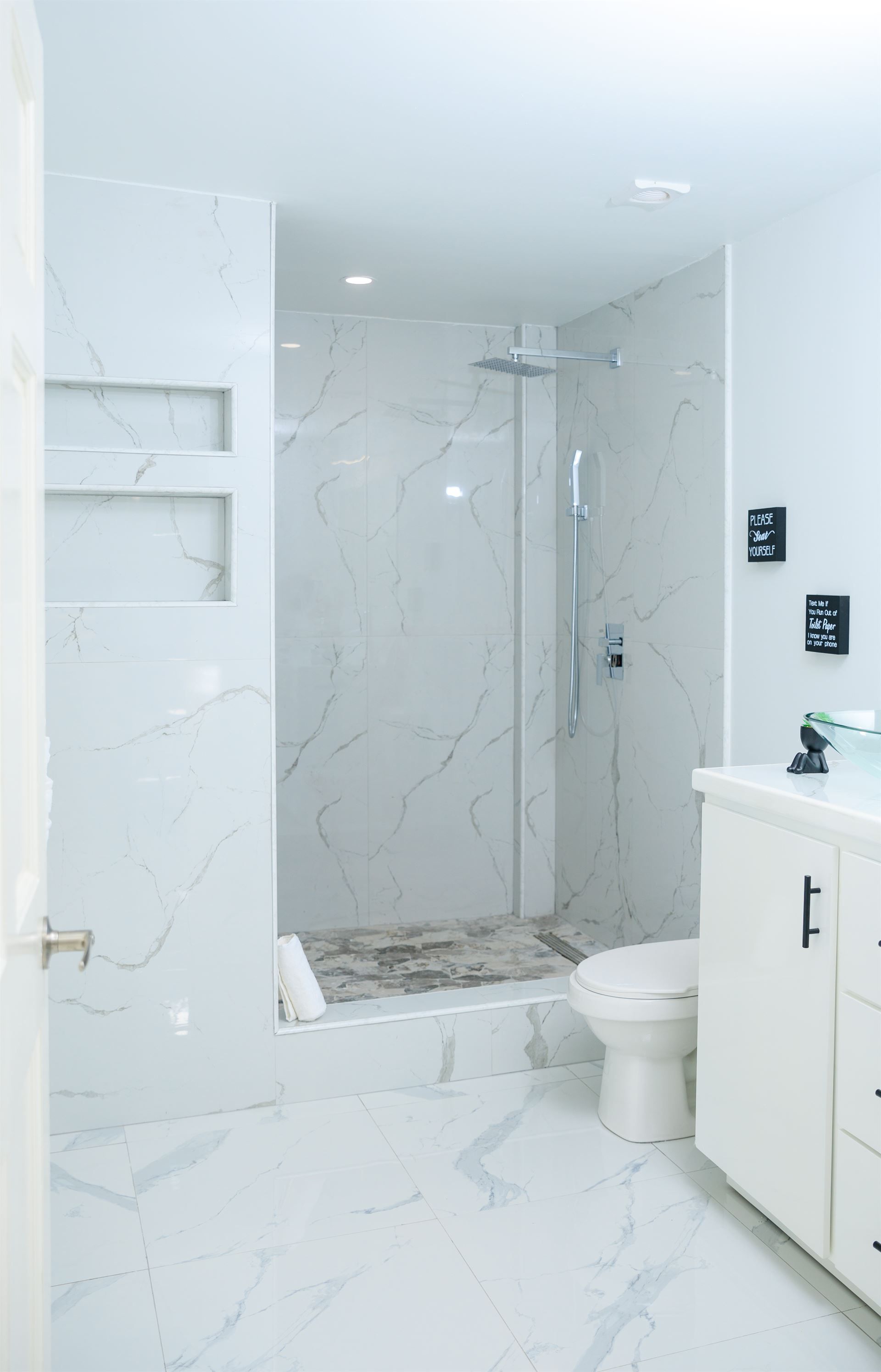 A bathroom with a toilet , sink , shower and walk in shower.