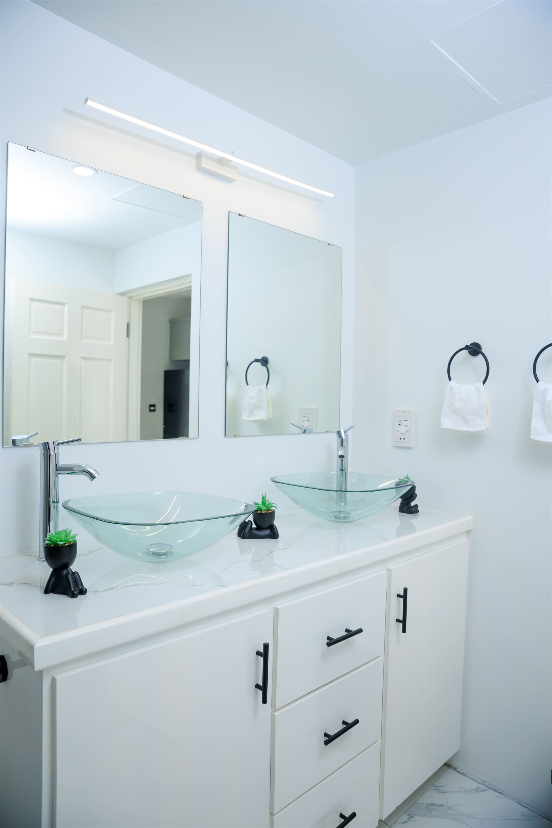 A bathroom with two sinks and a mirror.