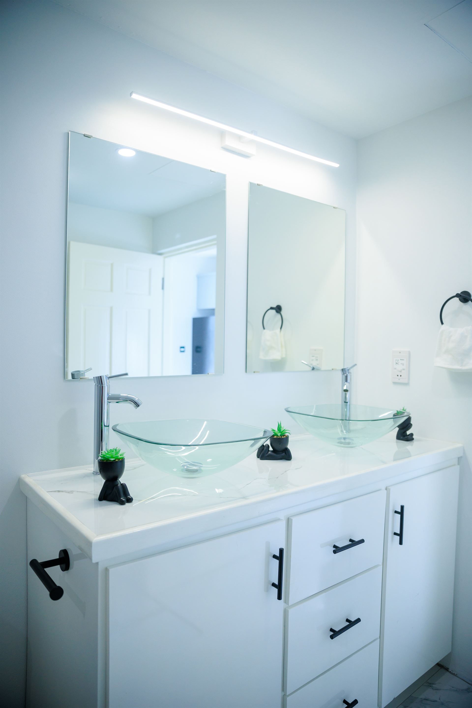 A bathroom with two sinks and a mirror.