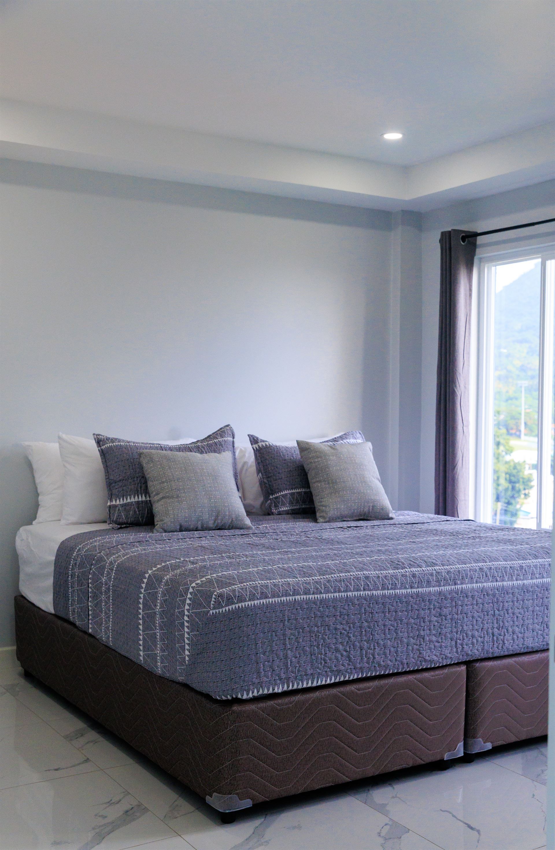 A bedroom with a large bed and a sliding glass door.