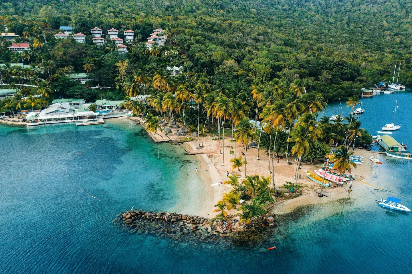 An aerial view of a small island in the middle of a body of water surrounded by trees.