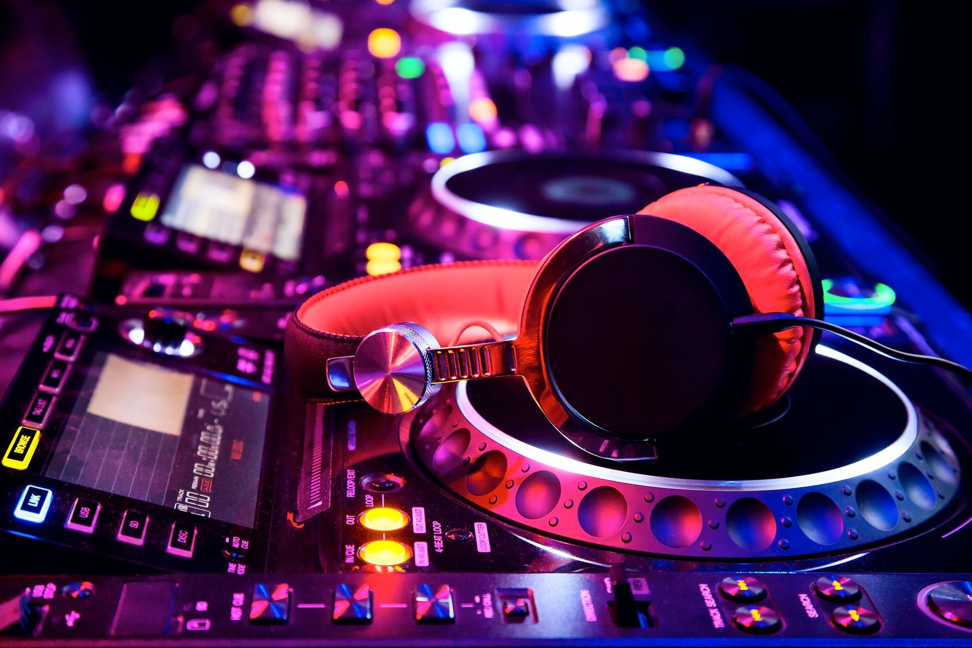 A pair of headphones sitting on top of a dj controller.