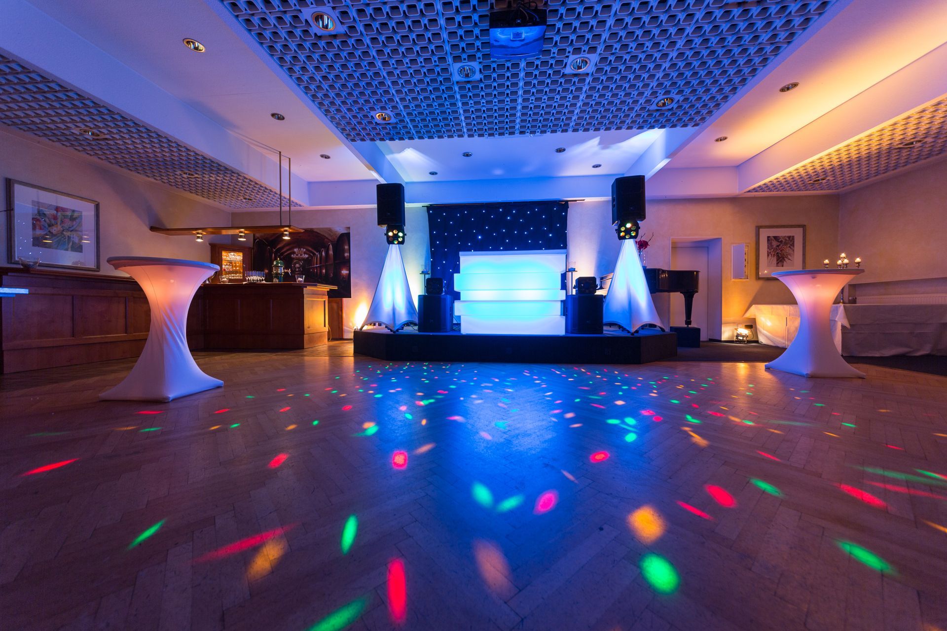 A large room with a dance floor and a dj on it.