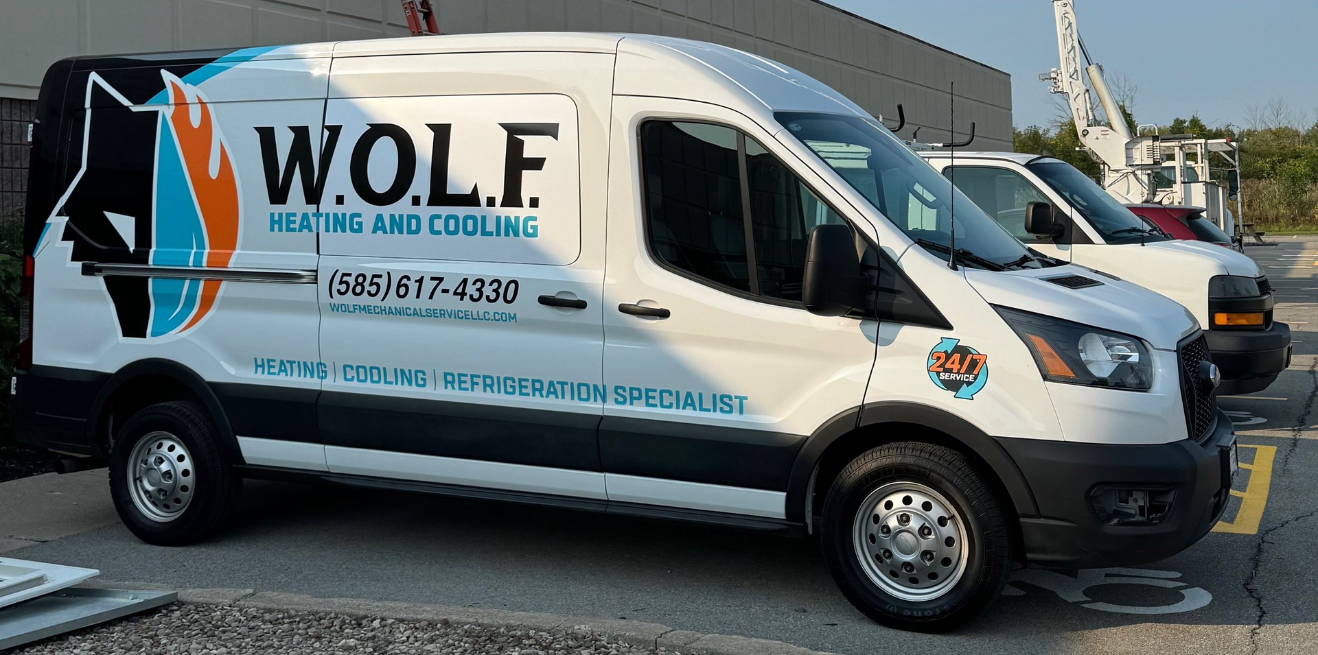 A wolf heating and cooling van is parked in a parking lot.