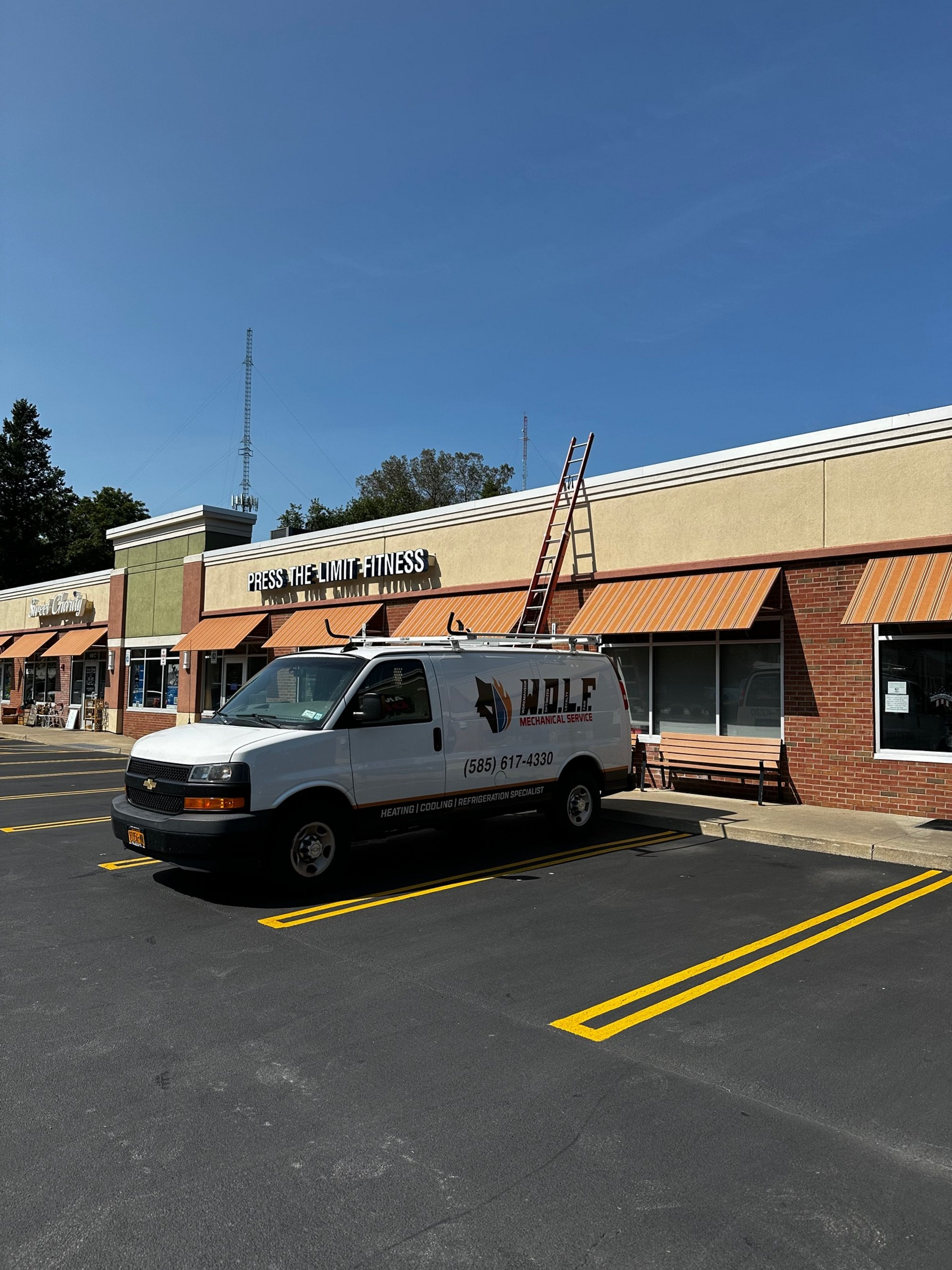 A white van is parked in front of a building.