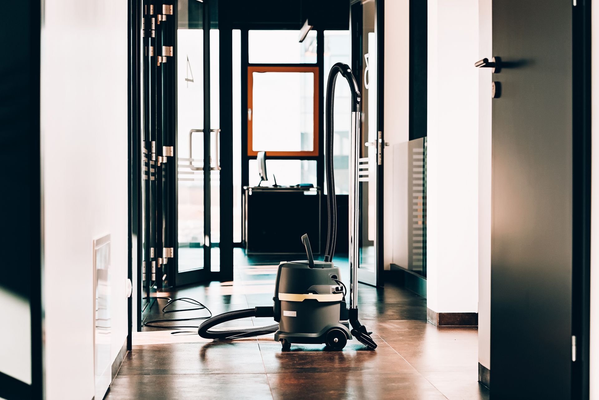 Un aspirapolvere è appoggiato sul pavimento in un corridoio.
