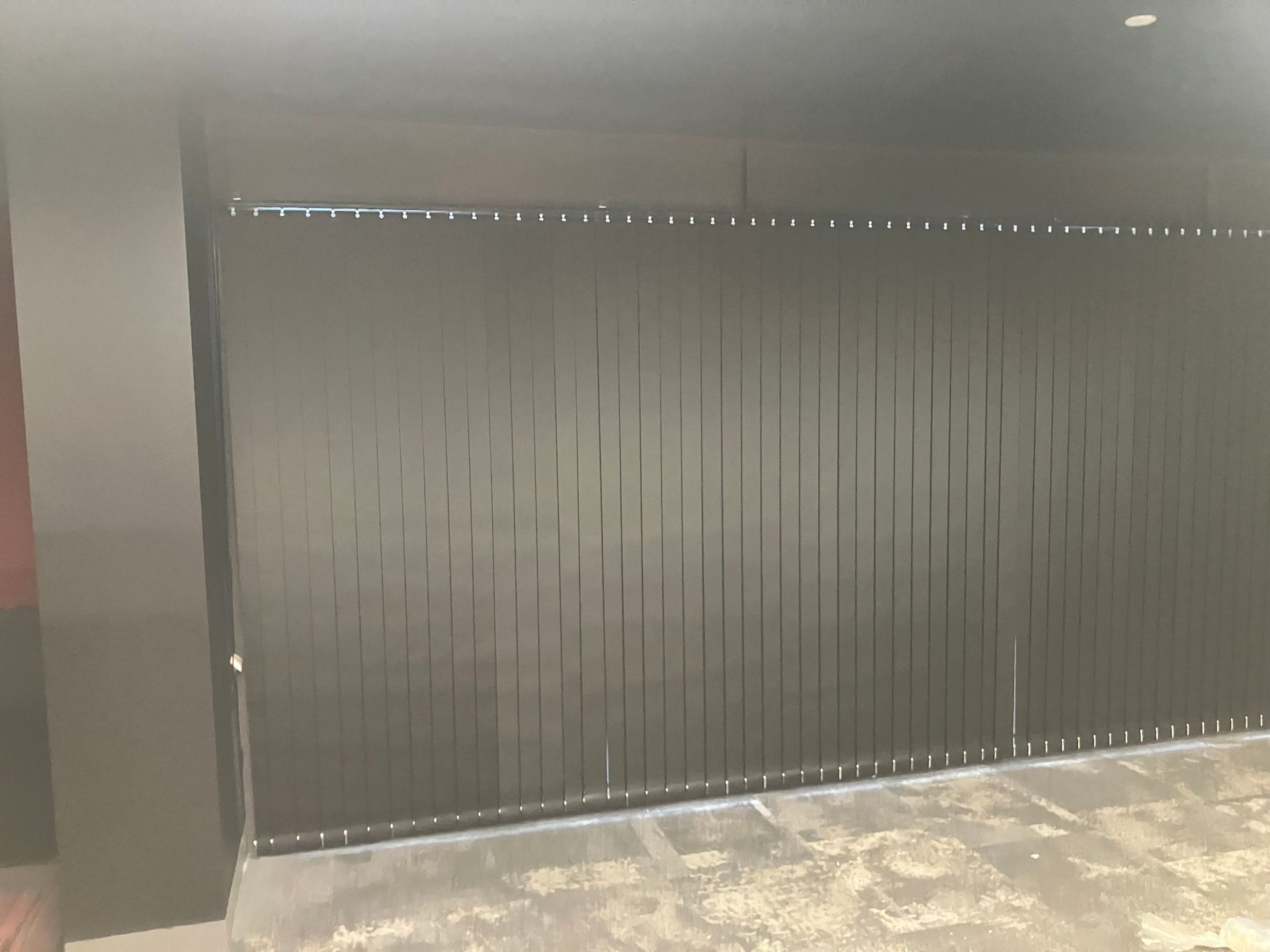 Black vertical slatted wall or gate beside a polished floor in an indoor space
