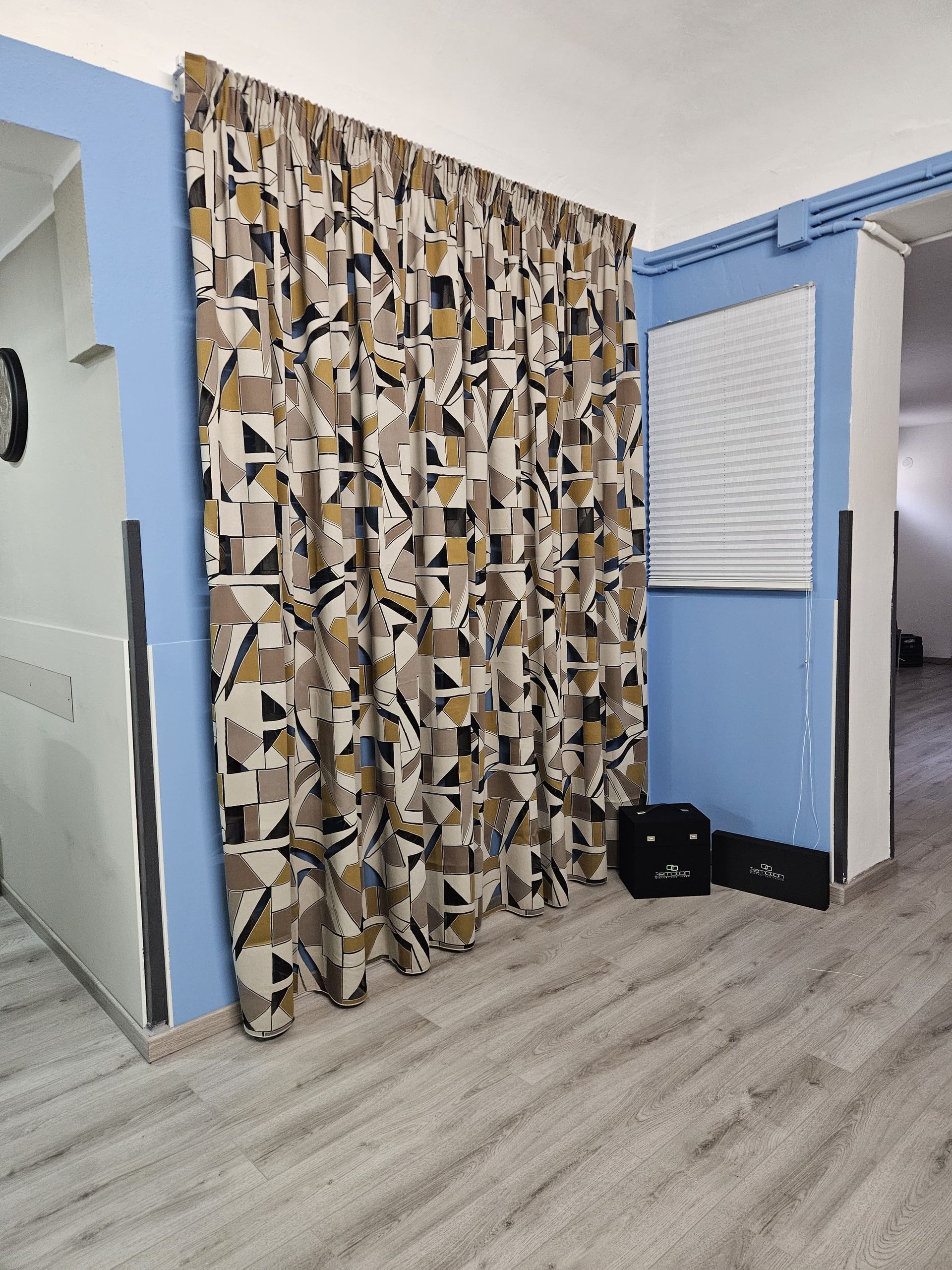 Una stanza con una tenda a motivi geometrici sul muro