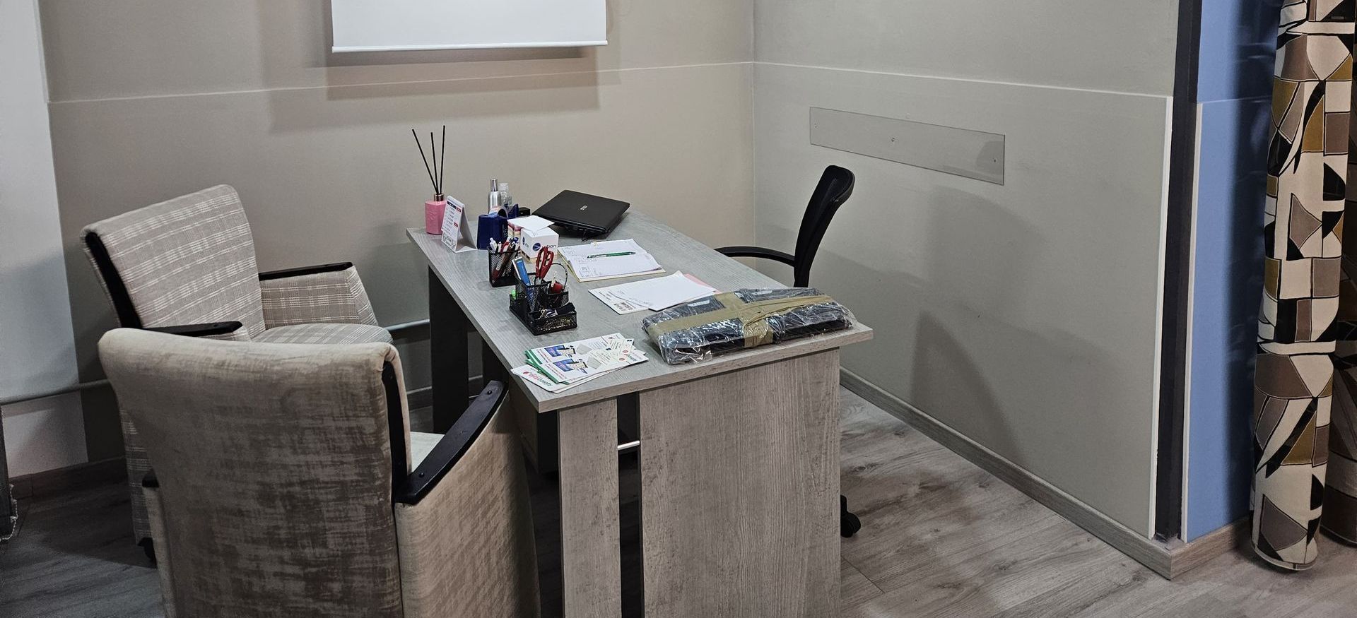 Una stanza con una scrivania e delle sedie.