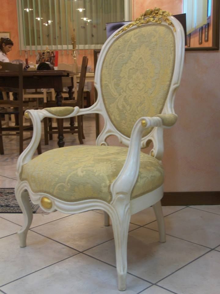 Una sedia bianca con un cuscino giallo è appoggiata su un pavimento piastrellato