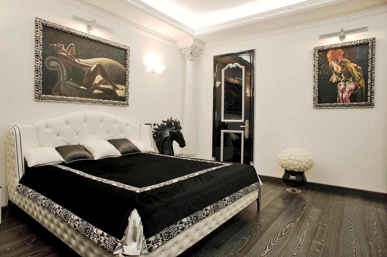 Una camera da letto con un letto nero e due quadri sul muro