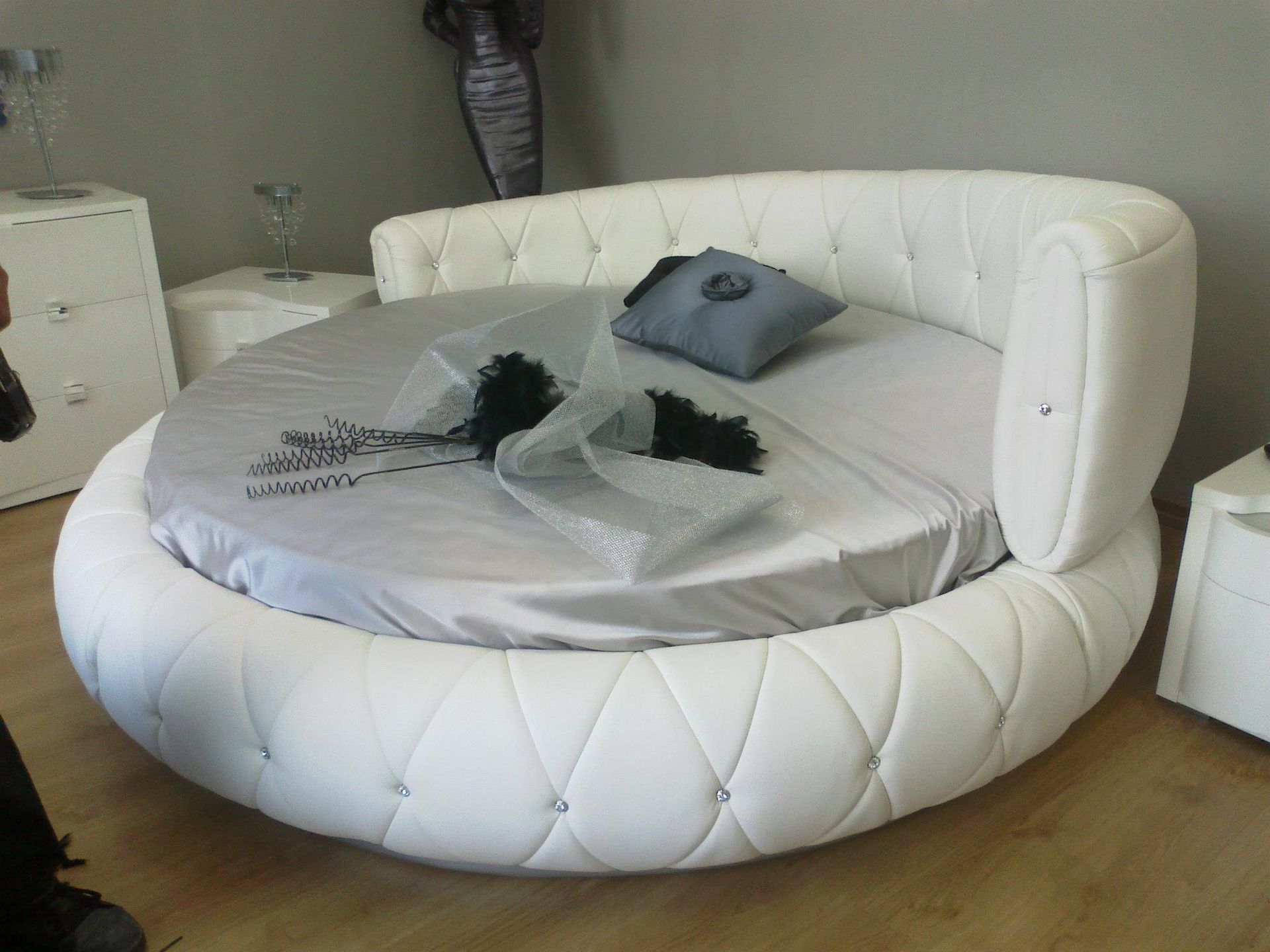 Un letto rotondo in una camera da letto con cuscini sopra