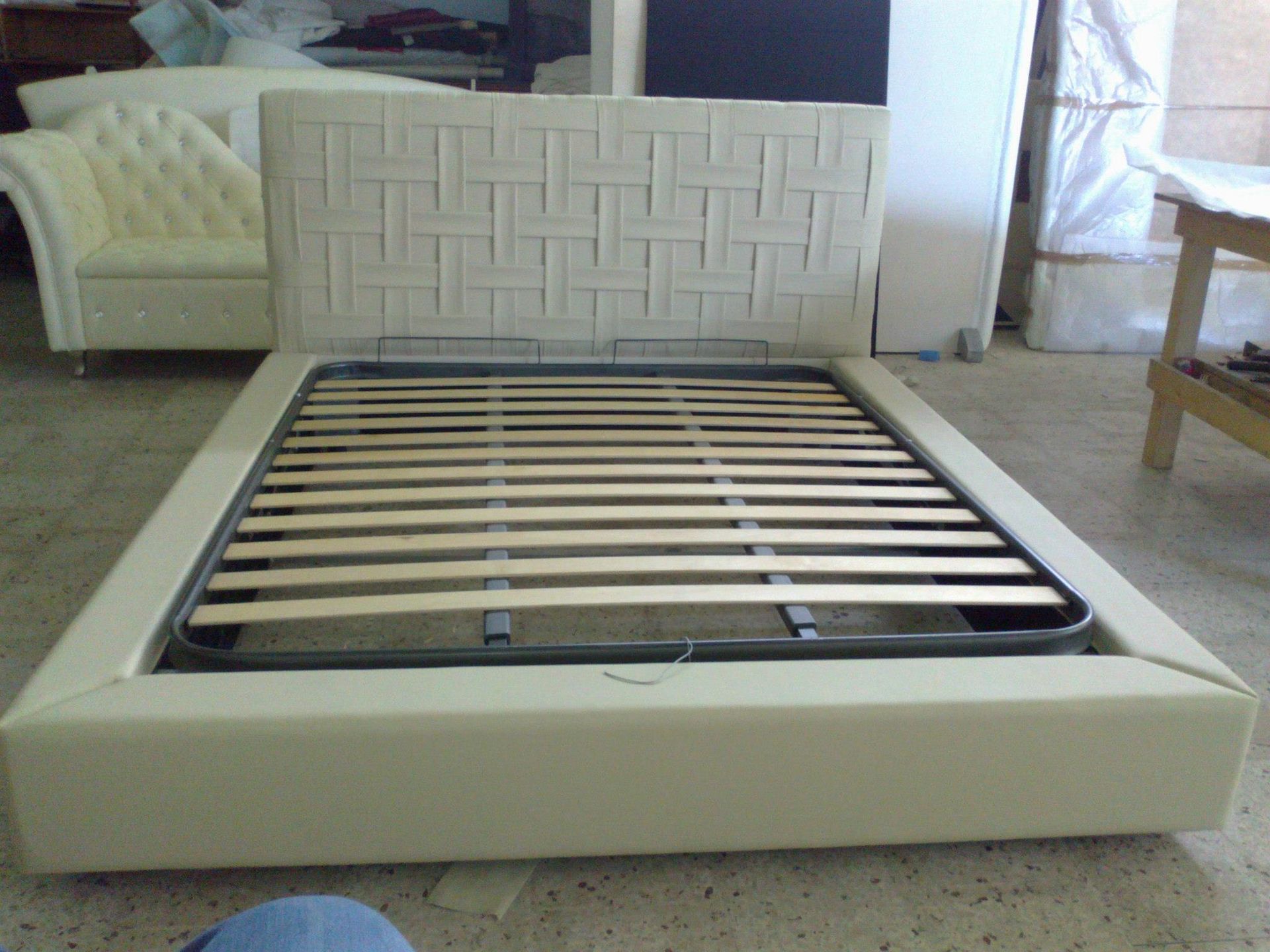 Una struttura del letto con testiera bianca e doghe