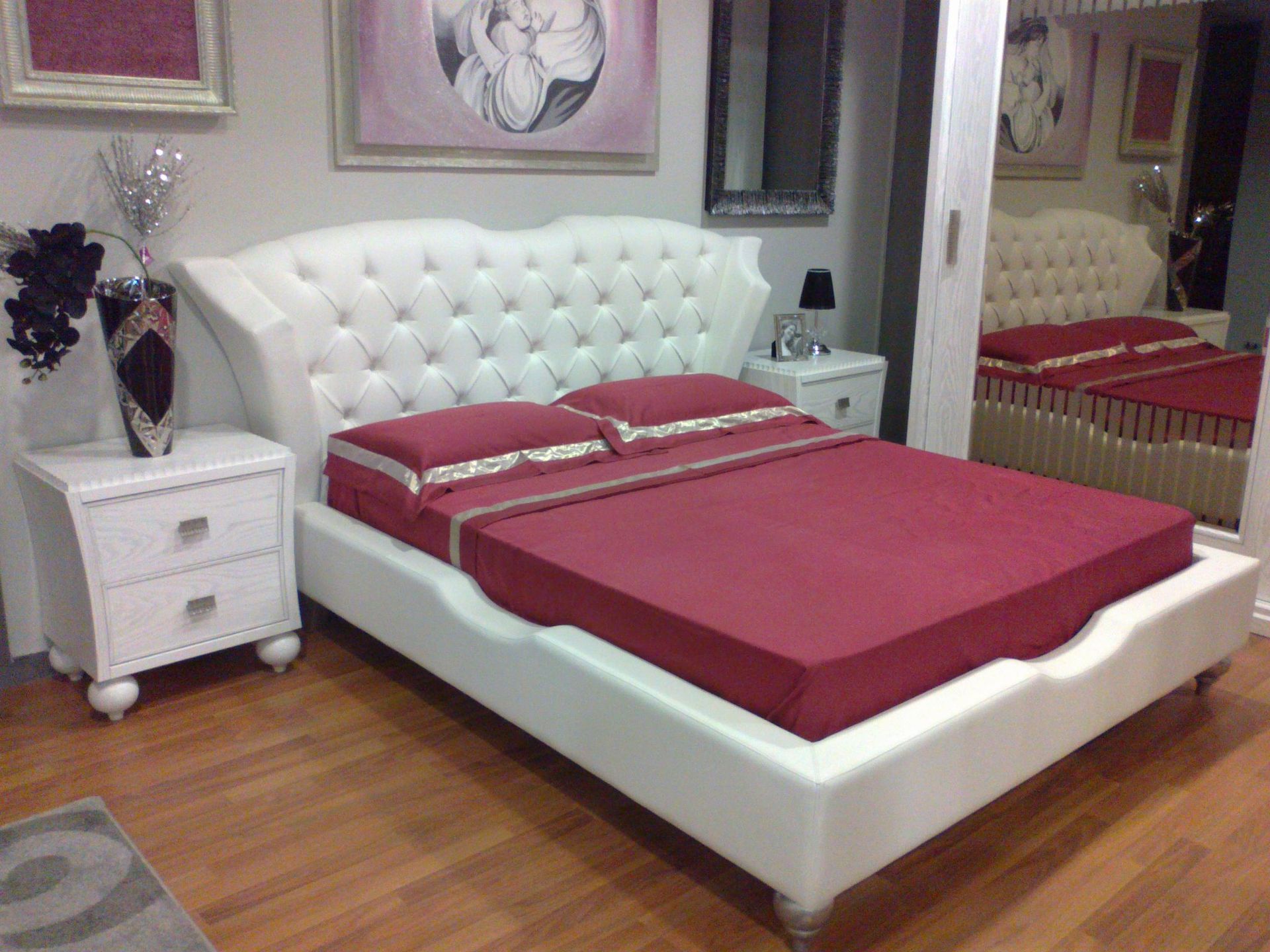 Una camera da letto con un letto bianco e lenzuola rosse