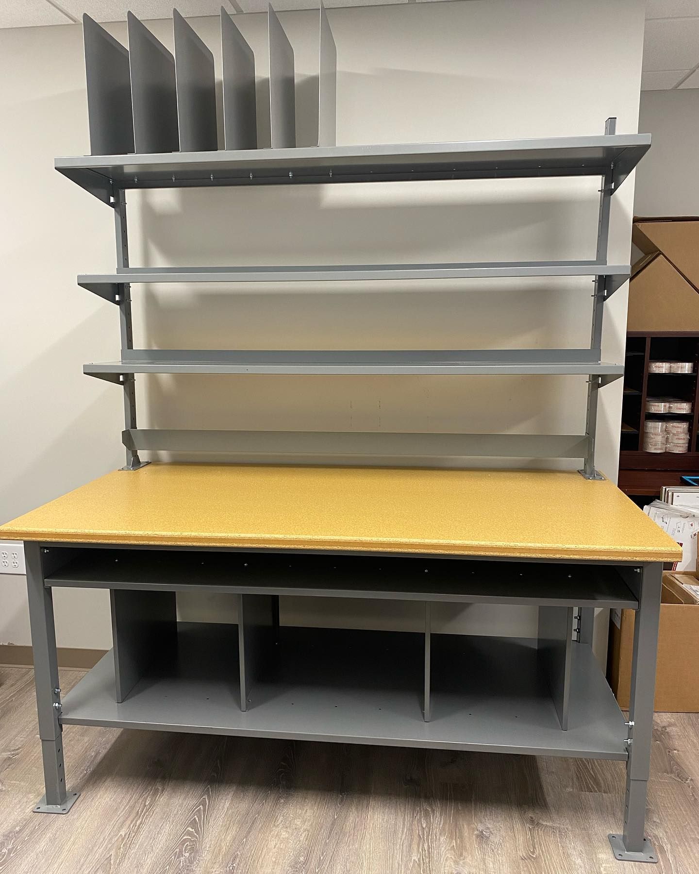 Gray and tan workstation with shelving and dividers for mail or documents.