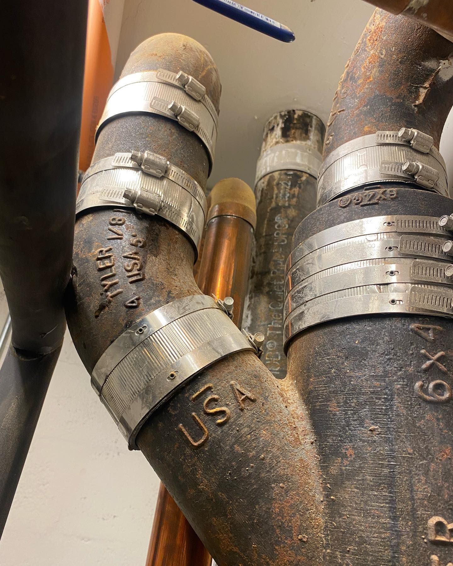 Black pipes with metal clamps and USA marking, likely part of plumbing or a similar system.