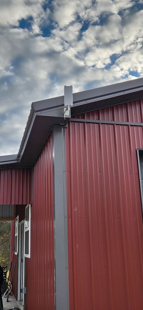 Red wooden building corner against a cloudy sky