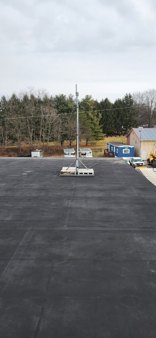 Snow-covered parking lot with scattered equipment and trees in the background