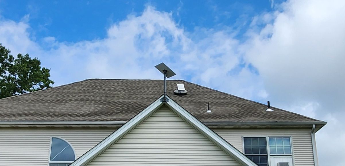 House roof with solar panel under a blue sky