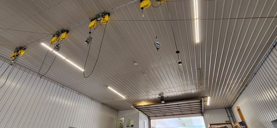 Yellow hanging lights on a perforated metal ceiling inside a partially finished room