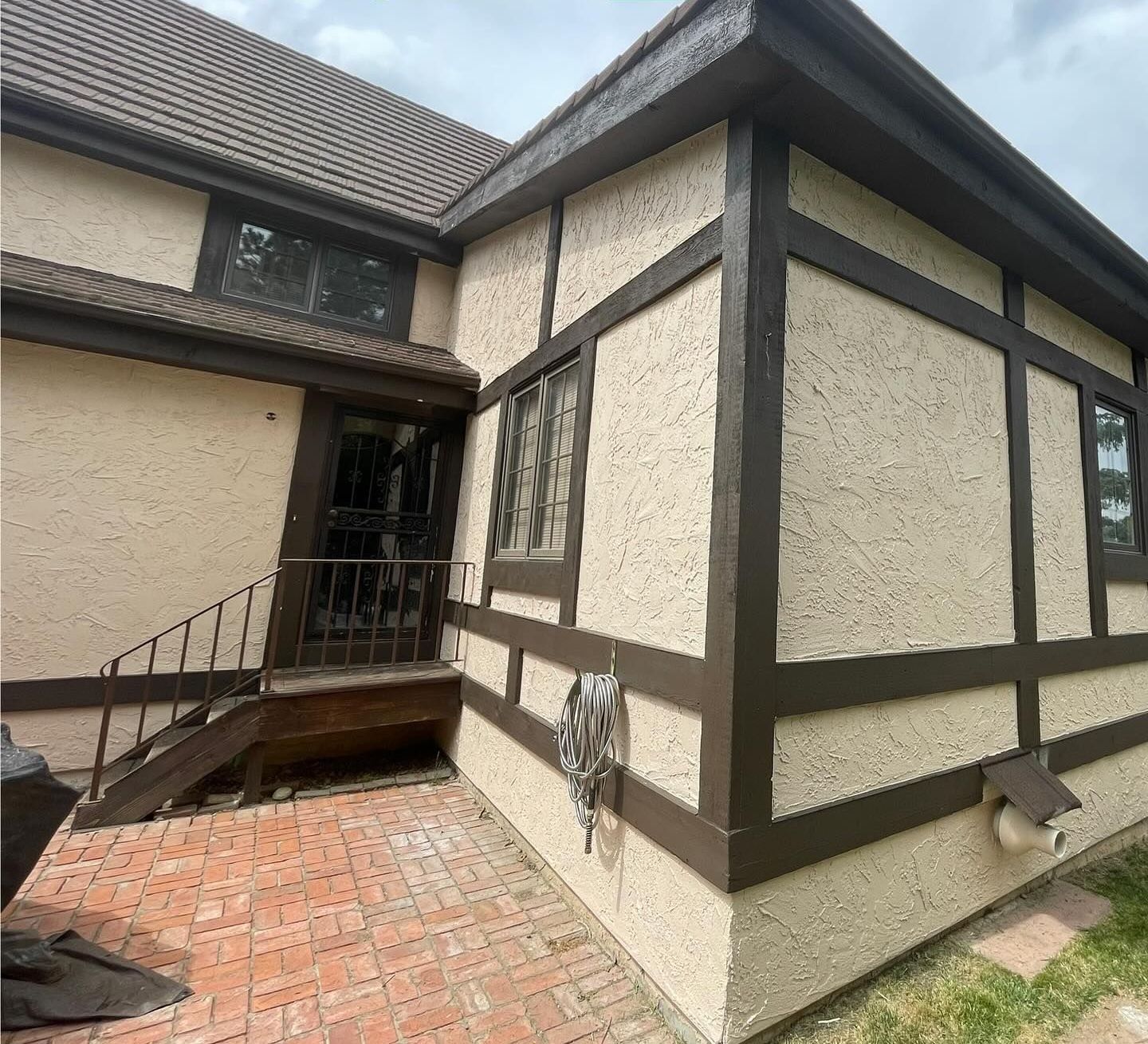 A house with a brick walkway and stairs on the side of it.