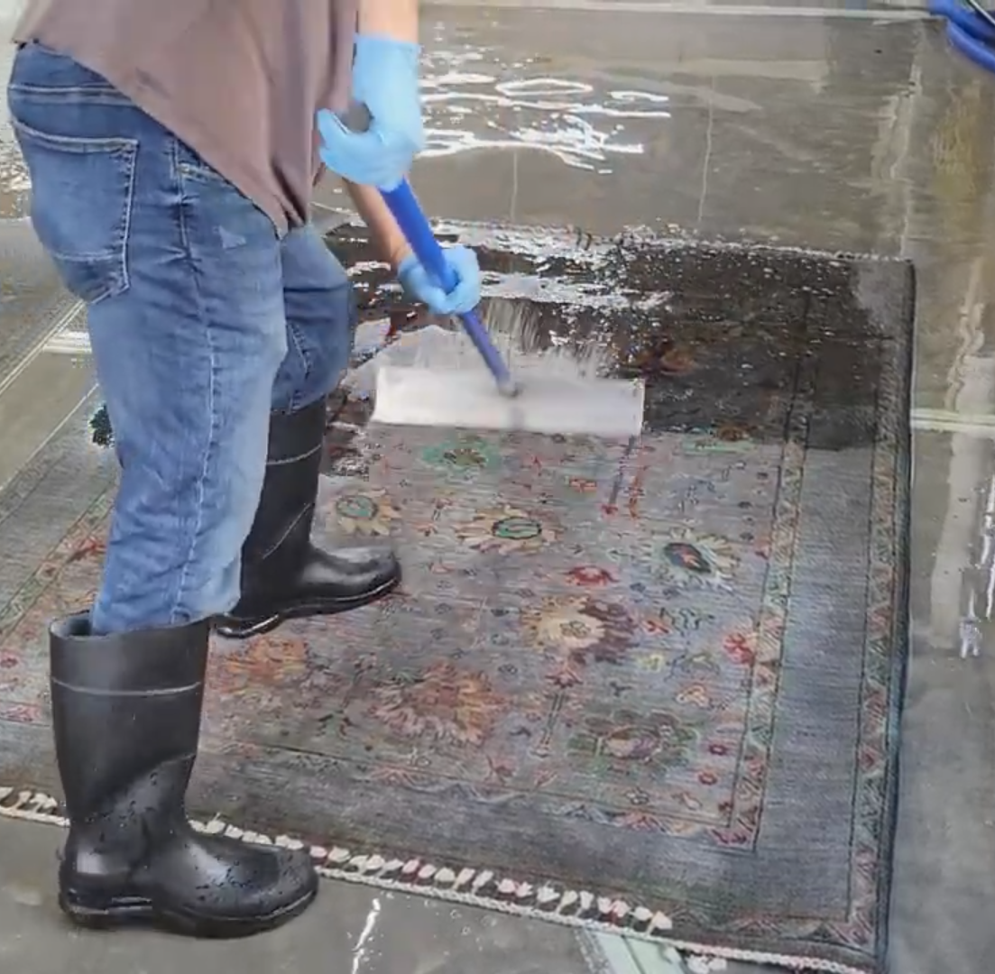 A vacuum cleaner is being used to clean a carpet.