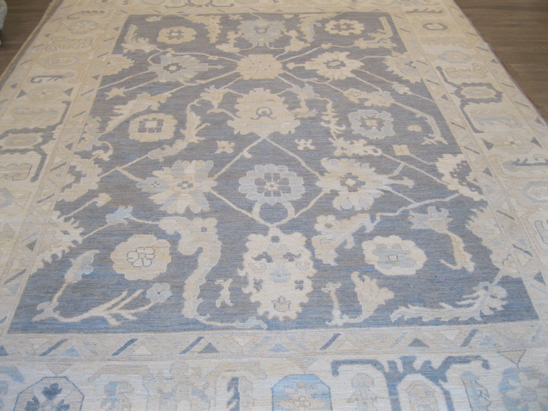 A rug with a pattern of flowers and leaves on it