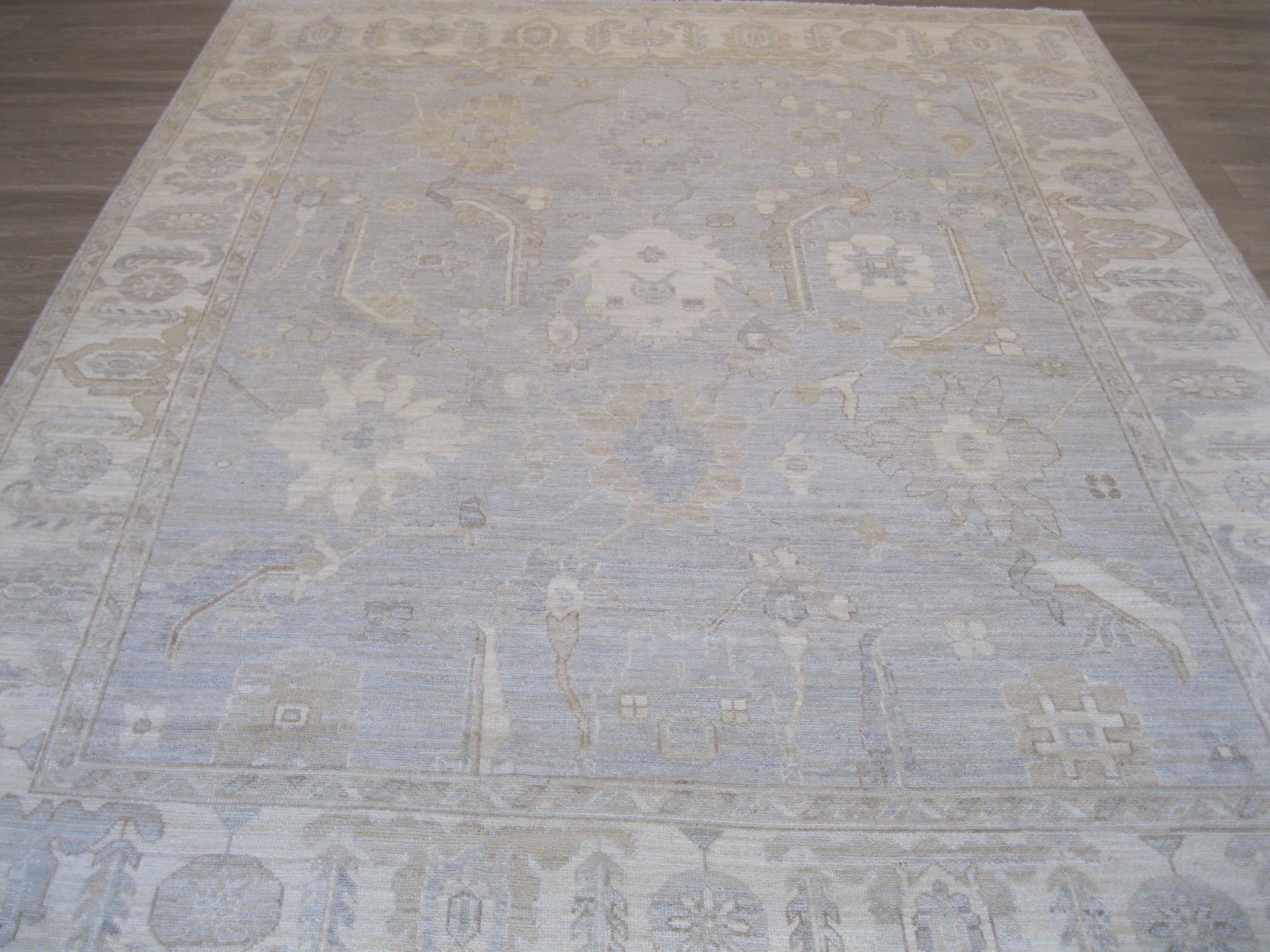 A large white rug is sitting on a wooden floor.