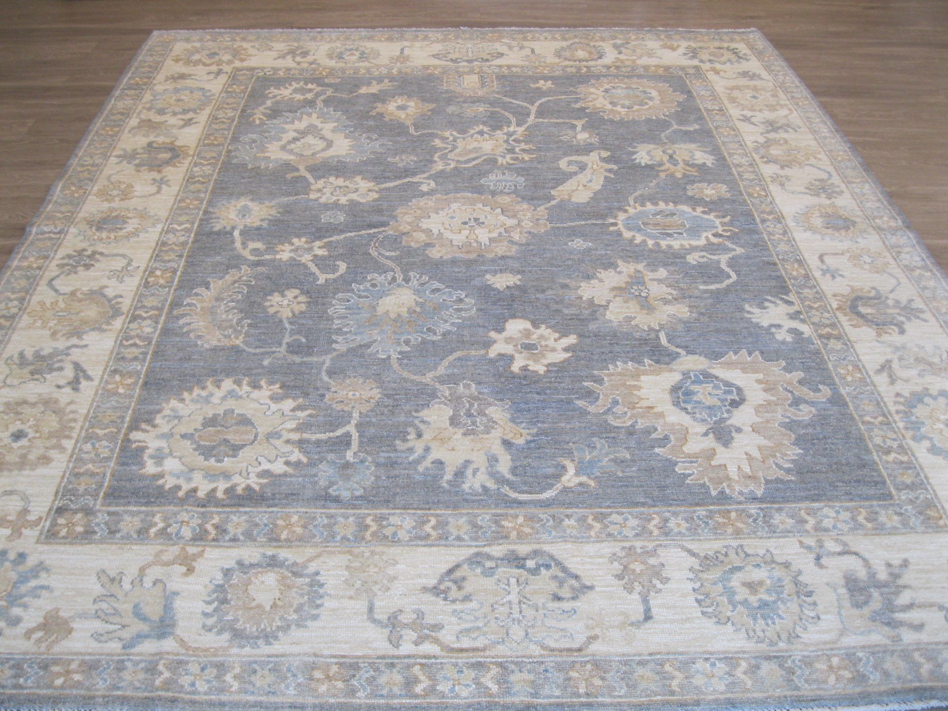 A rug with a floral pattern is sitting on a wooden floor.