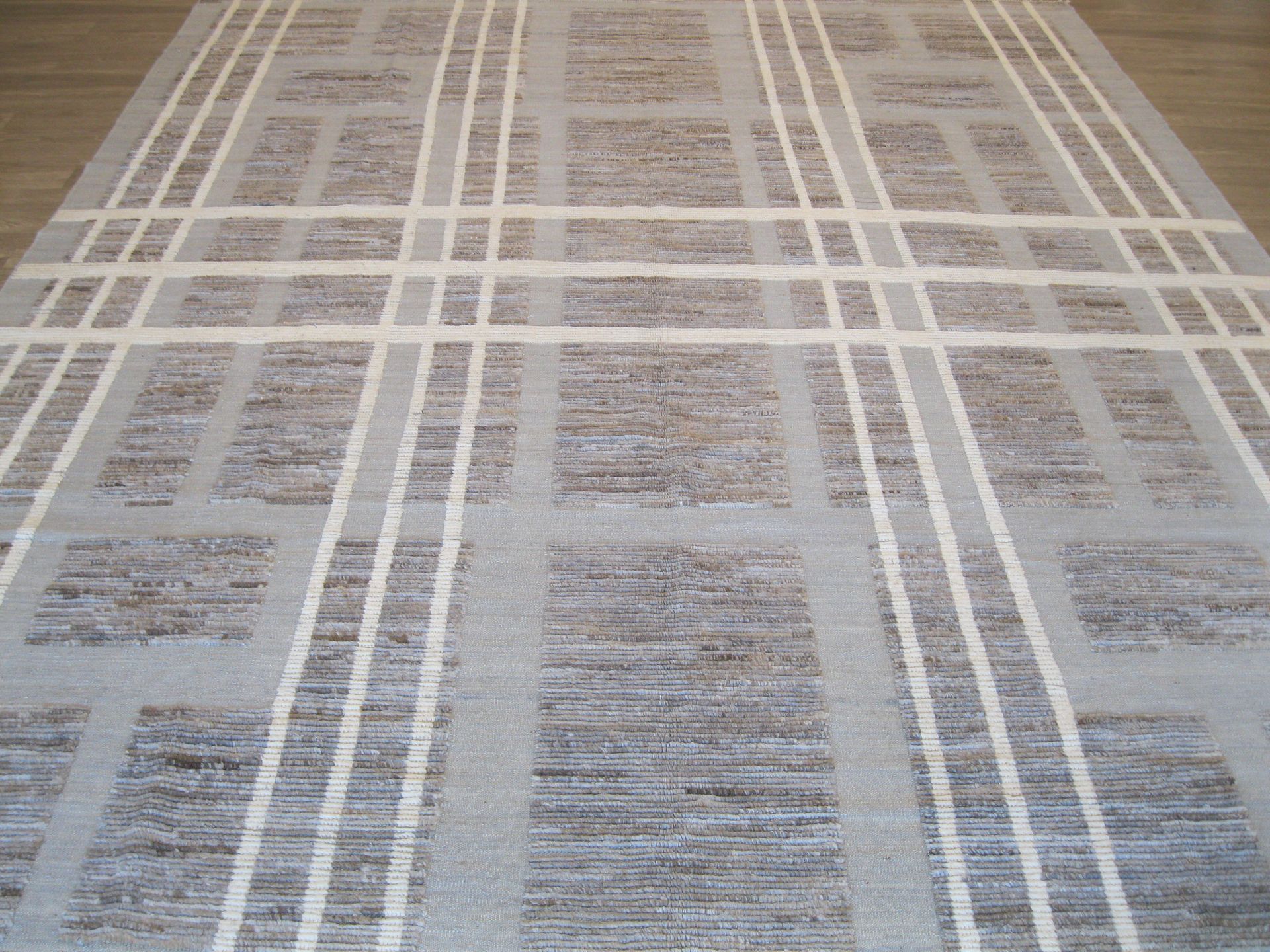 A rug with a pattern on it is sitting on a wooden floor.